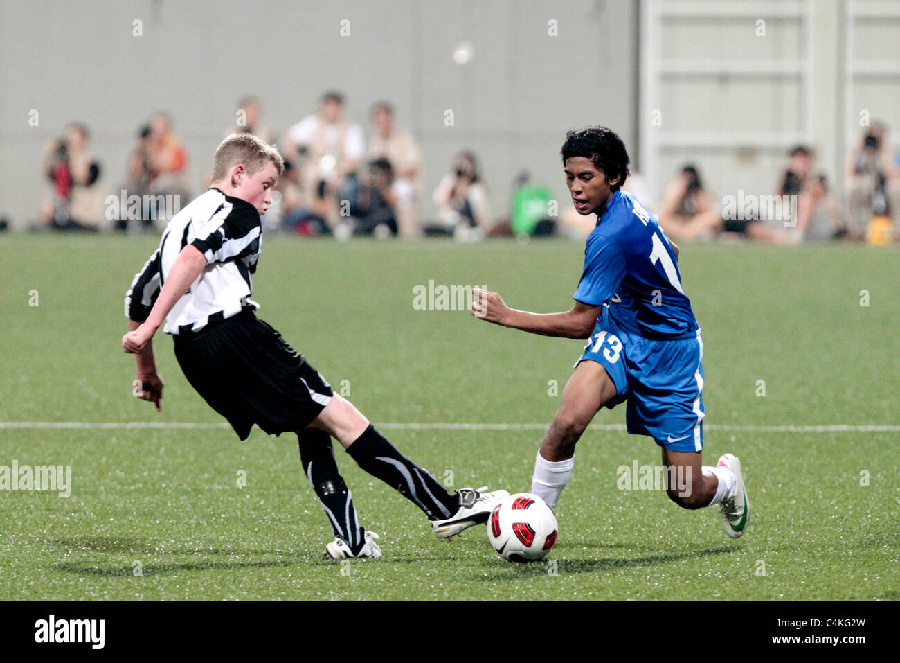 Rifqi Yazid von Singapur U15(blue) entzieht sich der Herausforderung von Dean Briggs während des 23. Canon Lion City Cup. Stockfoto