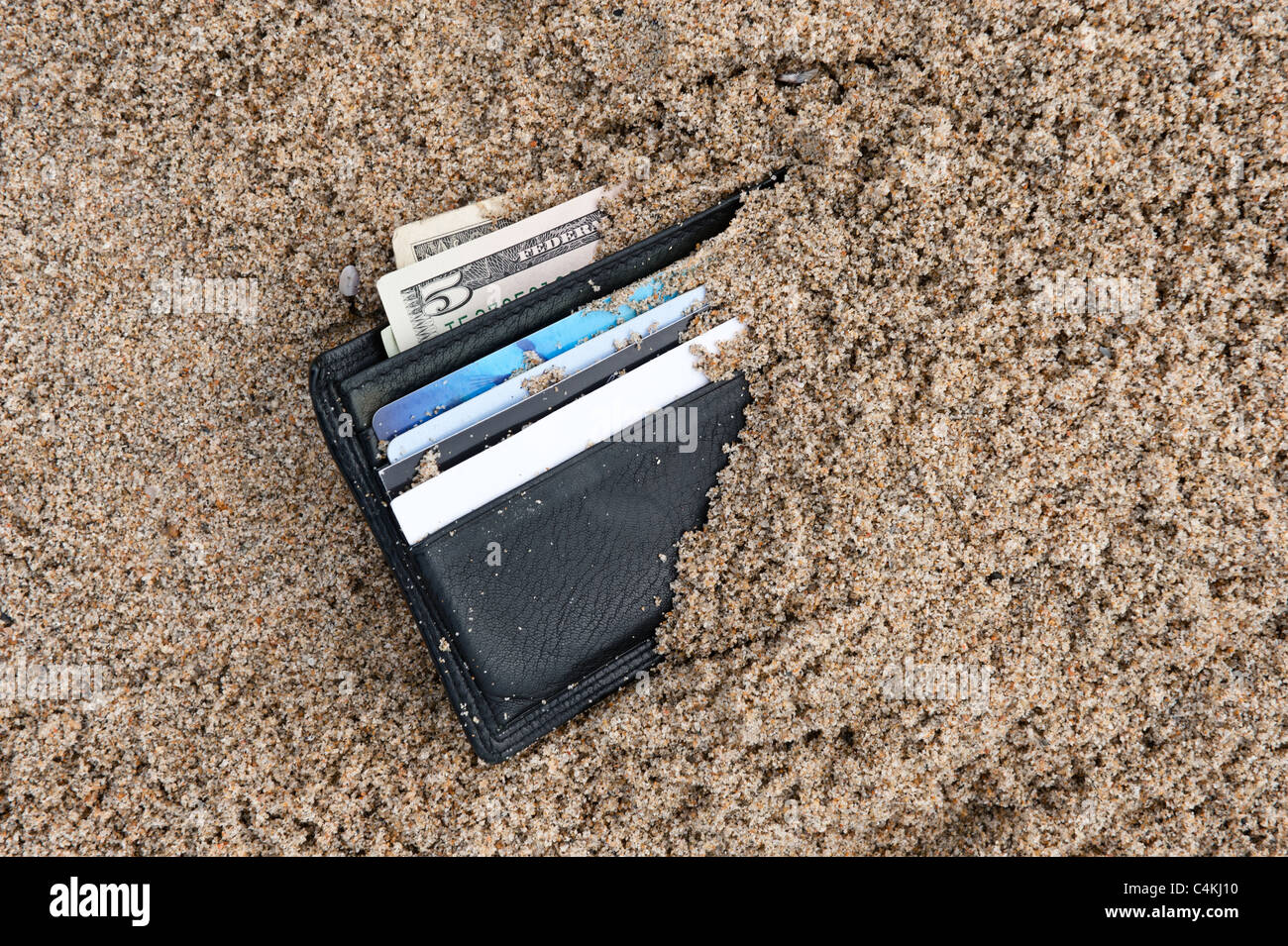 Eine verlorene Brieftasche am Strand mit Bargeld und Kreditkarten Stockfoto