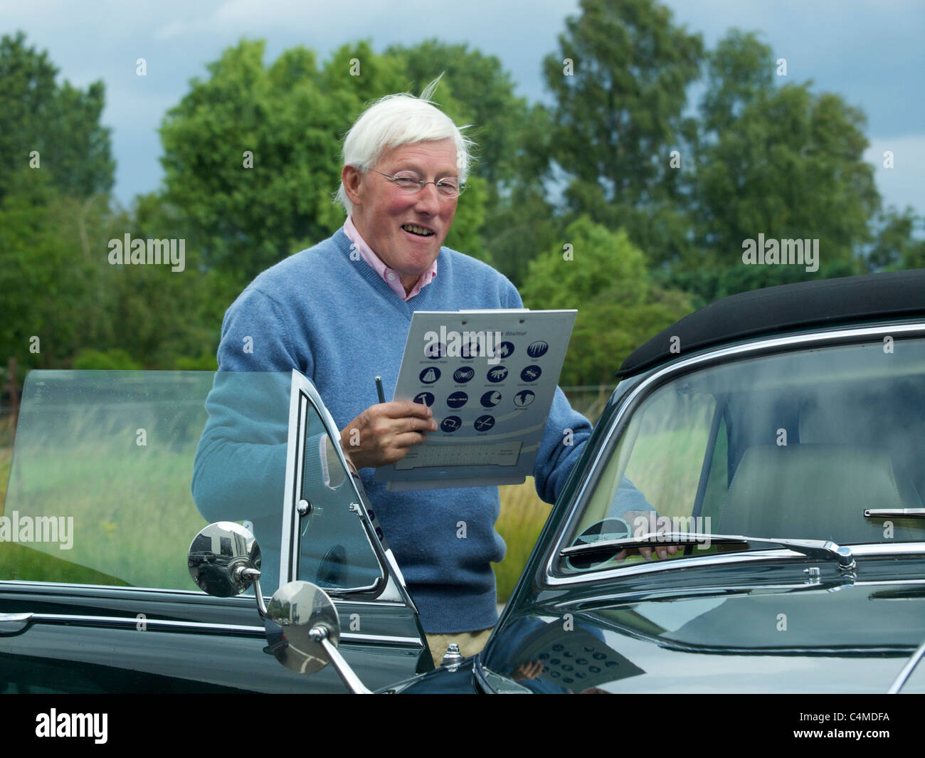Ältere Gentleman-Co-Pilot mit Roadbook, in einem klassischen Jaguar bei Rallye für historische Automobile Stockfoto