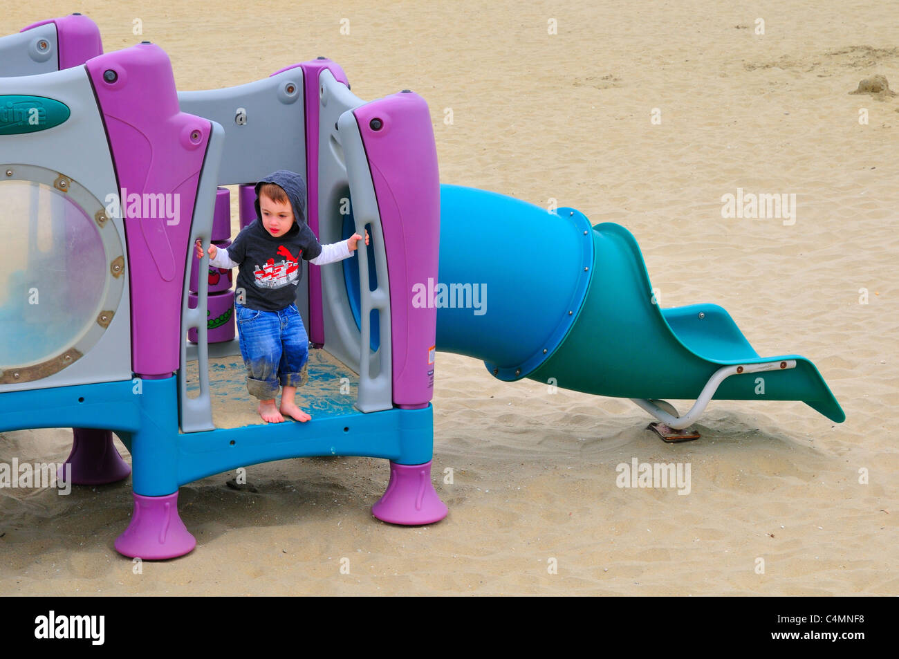 Ein kleiner Junge auf einem Spielplatz am Strand bei Avon-by-the-Sea, New Jersey Stockfoto