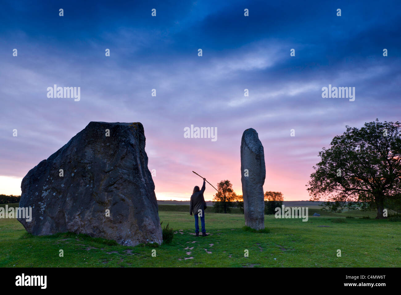 Gruß an die Sonne - ein Druide grüßt die Sonne zwischen den Steinen Avebury. Stockfoto