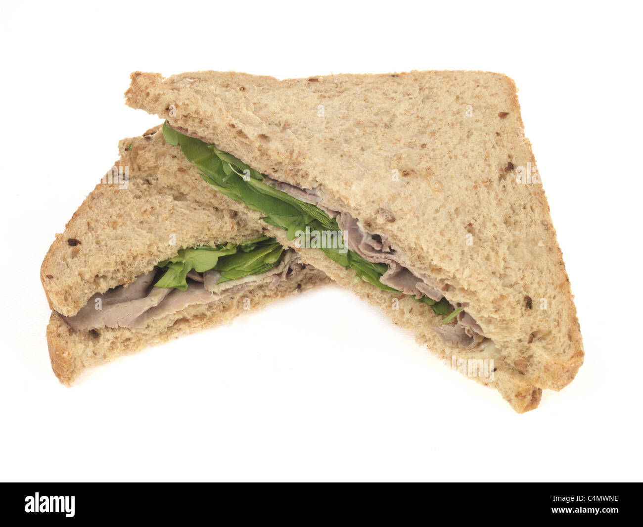 Frisch geschnittene Kaltes Roastbeef Sandwich mit Salat in gesundes Brot gegen einen weißen Hintergrund mit keine Personen einen Freistellungspfad und Kopieren Raum Stockfoto