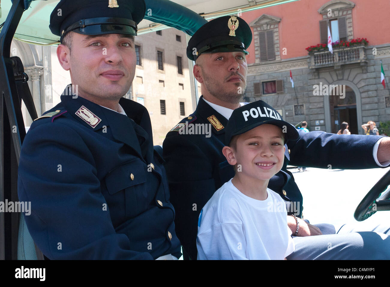 Zwei nationale italienische Polizei geben einen kleiner Junge mit Hut "Polizia" Baseball, eine Fahrt in einem Golfwagen. Stockfoto