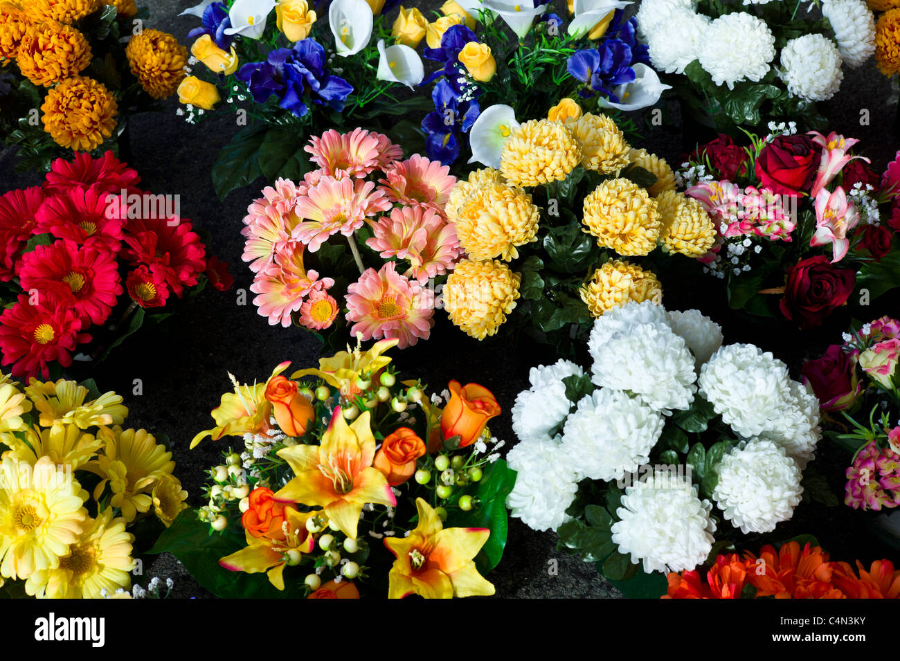 Stoff, künstliche Blumen, Gerbera, Chrysanthemen, Lilien zum Verkauf auf Markt in La Reole, Bordeaux Region von Frankreich Stockfoto