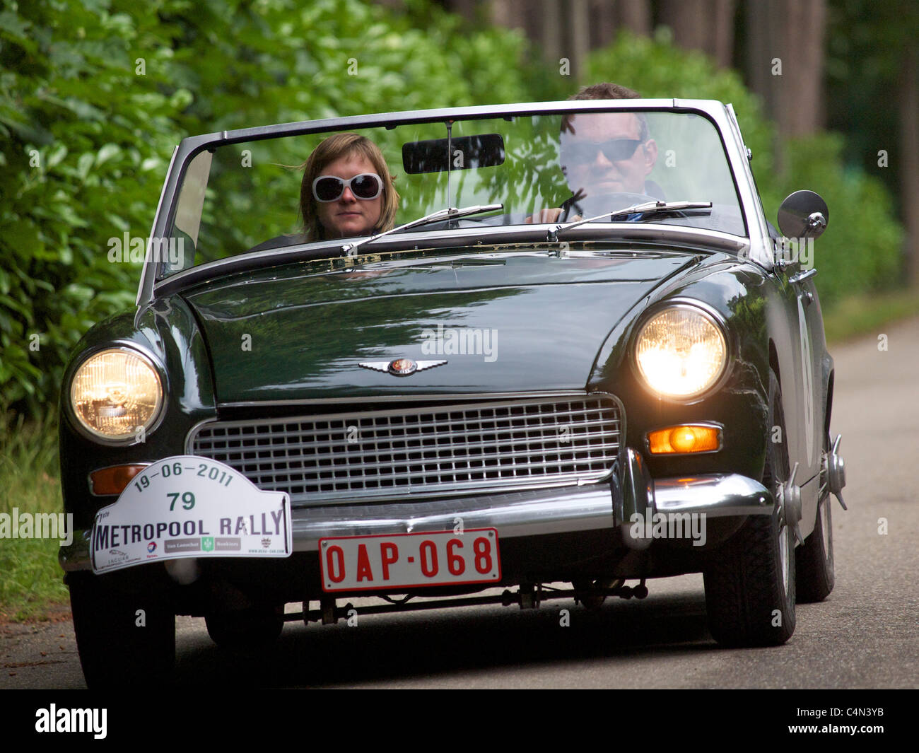 Paar fahren in ihren Austin Healey Sprite auf einer belgischen Landstrasse Stockfoto