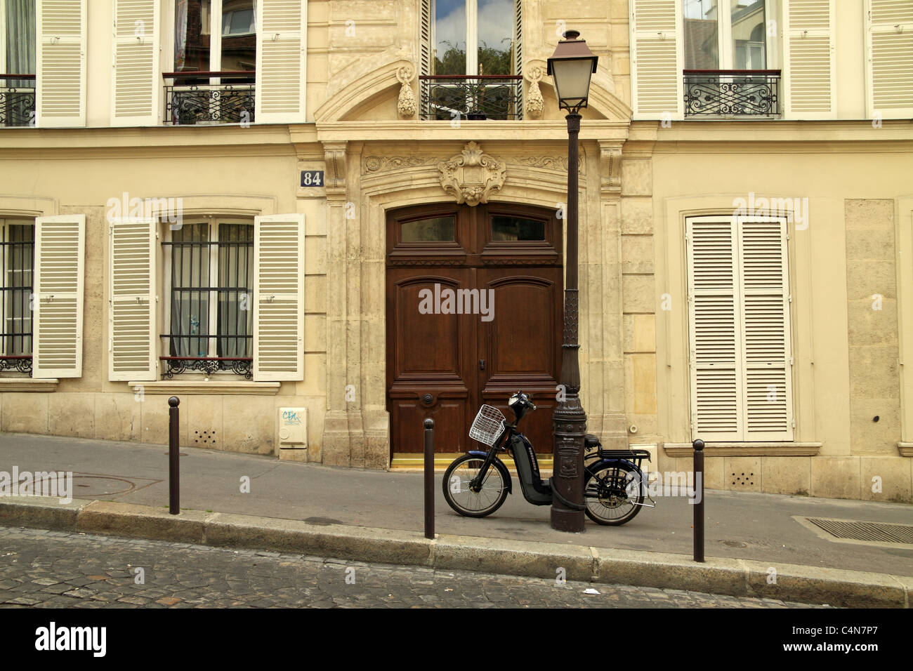 Eine typisch französische Straße in Montmartre, Paris, mit einem Motorrad auf einen Laternenpfahl gelehnt Stockfoto