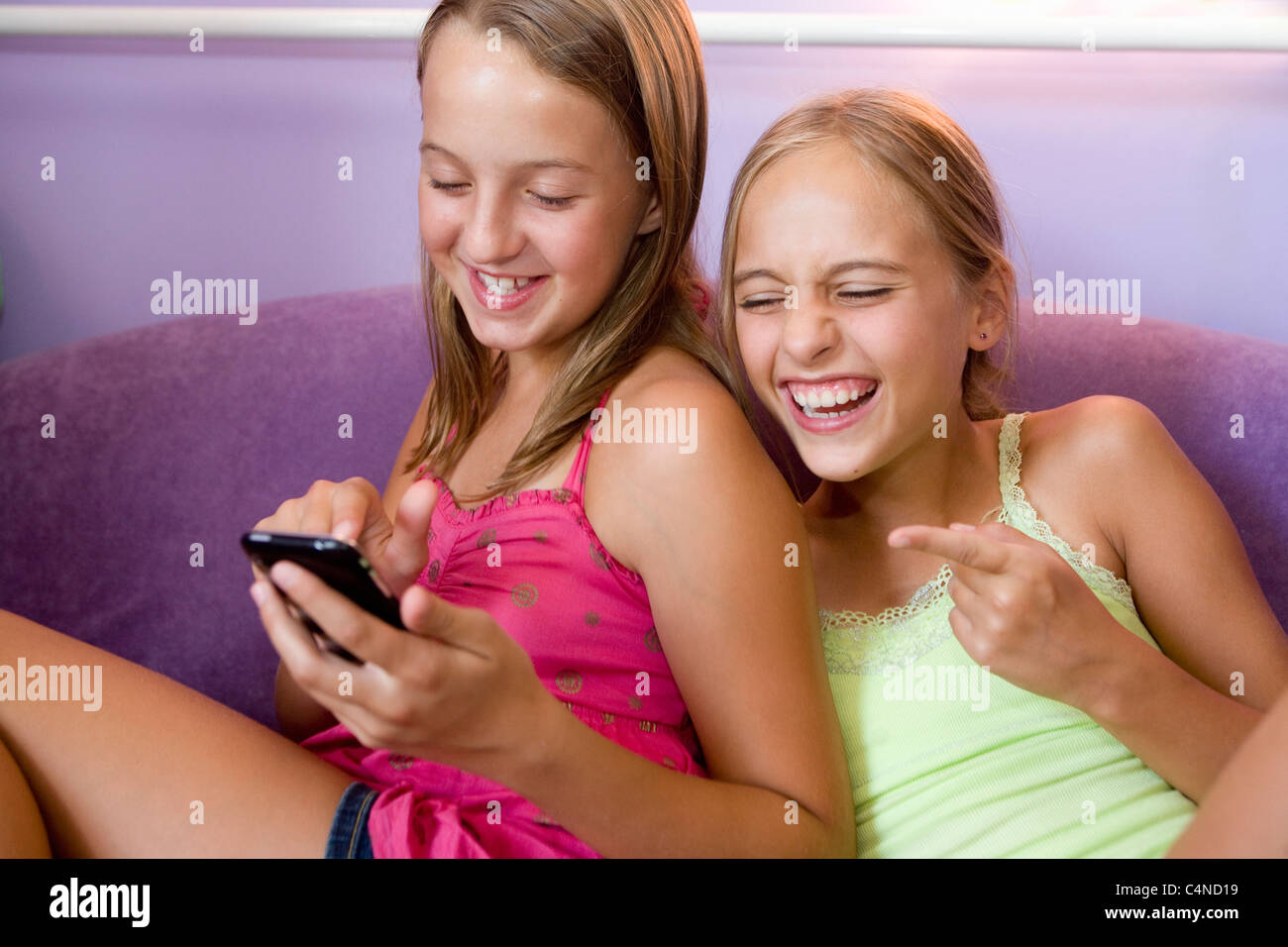 Zwei Mädchen spielen auf dem iPhone Stockfoto