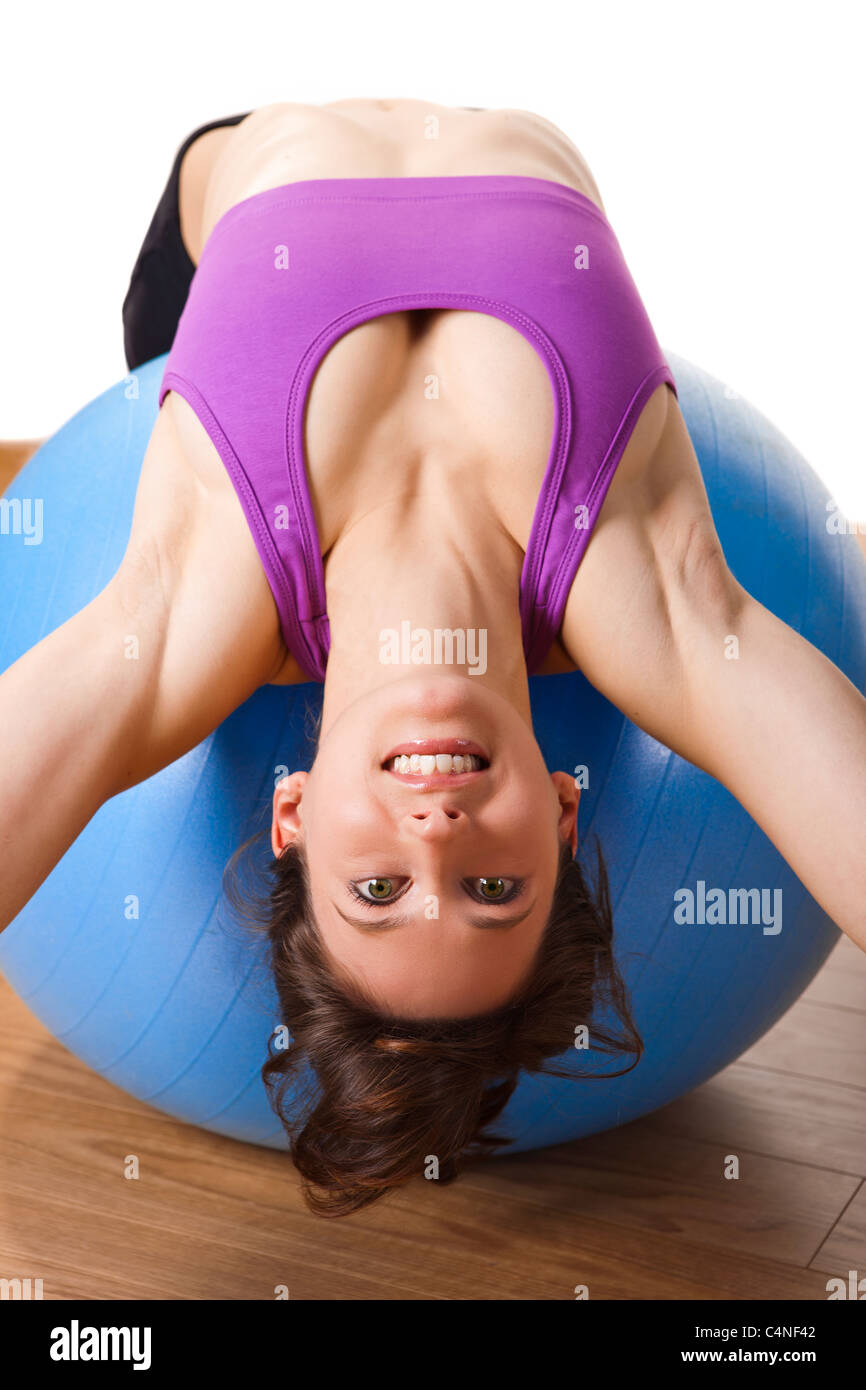 Schöne junge und sportliche Frau, die die Übungen auf einer Fitness-ball Stockfoto