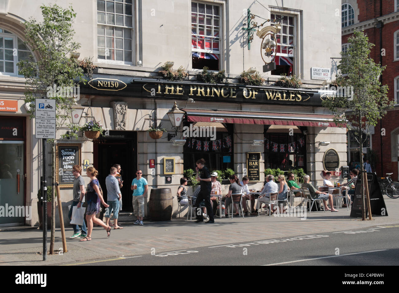 Menschen haben einen Drink am Nachmittag außerhalb der Prince Of Wales Gastwirtschaft in St Martins Lane, Covent Garden, London, Großbritannien. Stockfoto