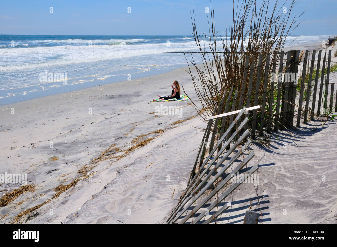 Frau sitzt am Strand in Brigantine Beach, New Jersey Stockfoto