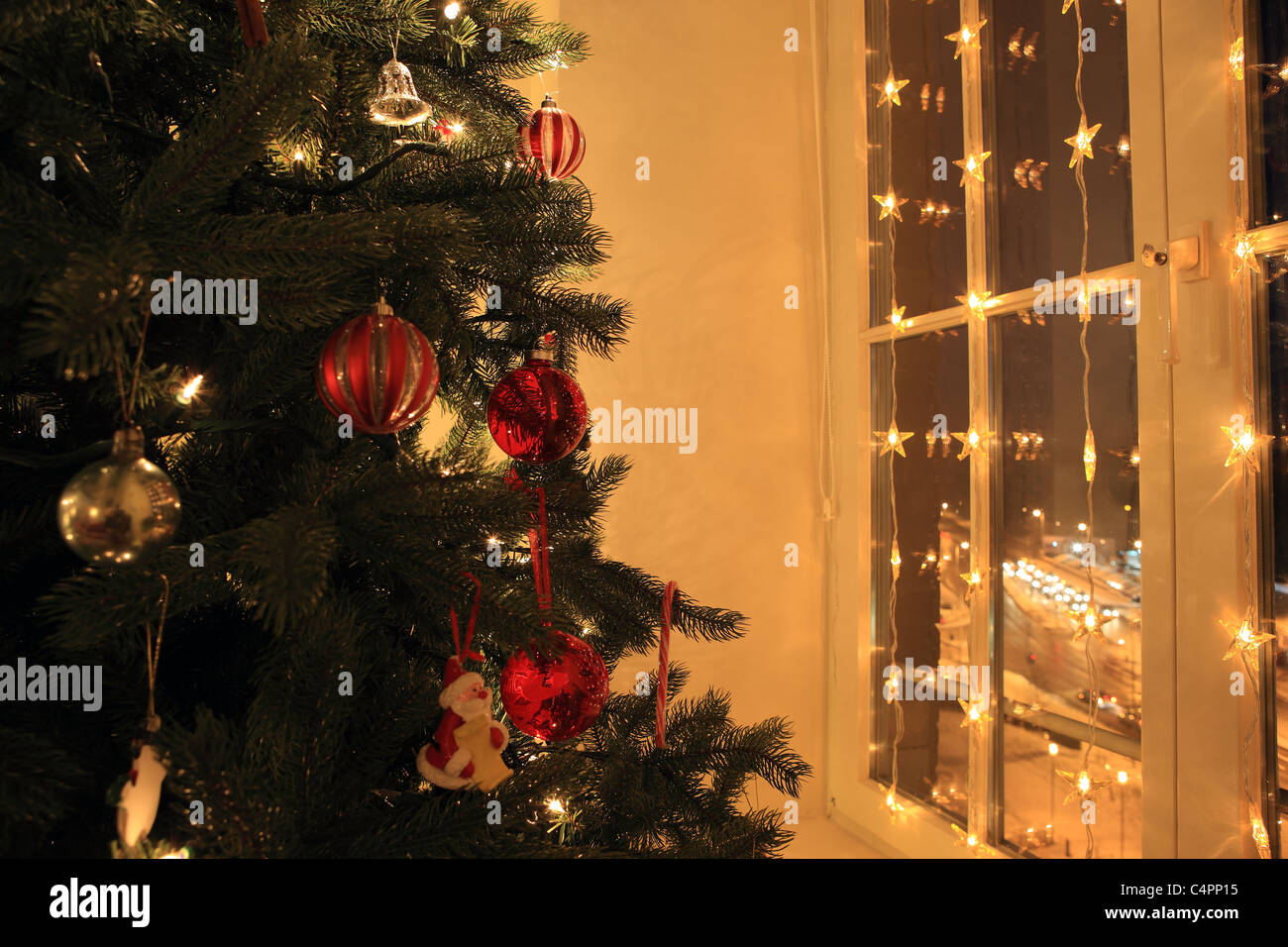 Weihnachtsbaum und Fenster mit Weihnachtsbeleuchtung Stockfoto