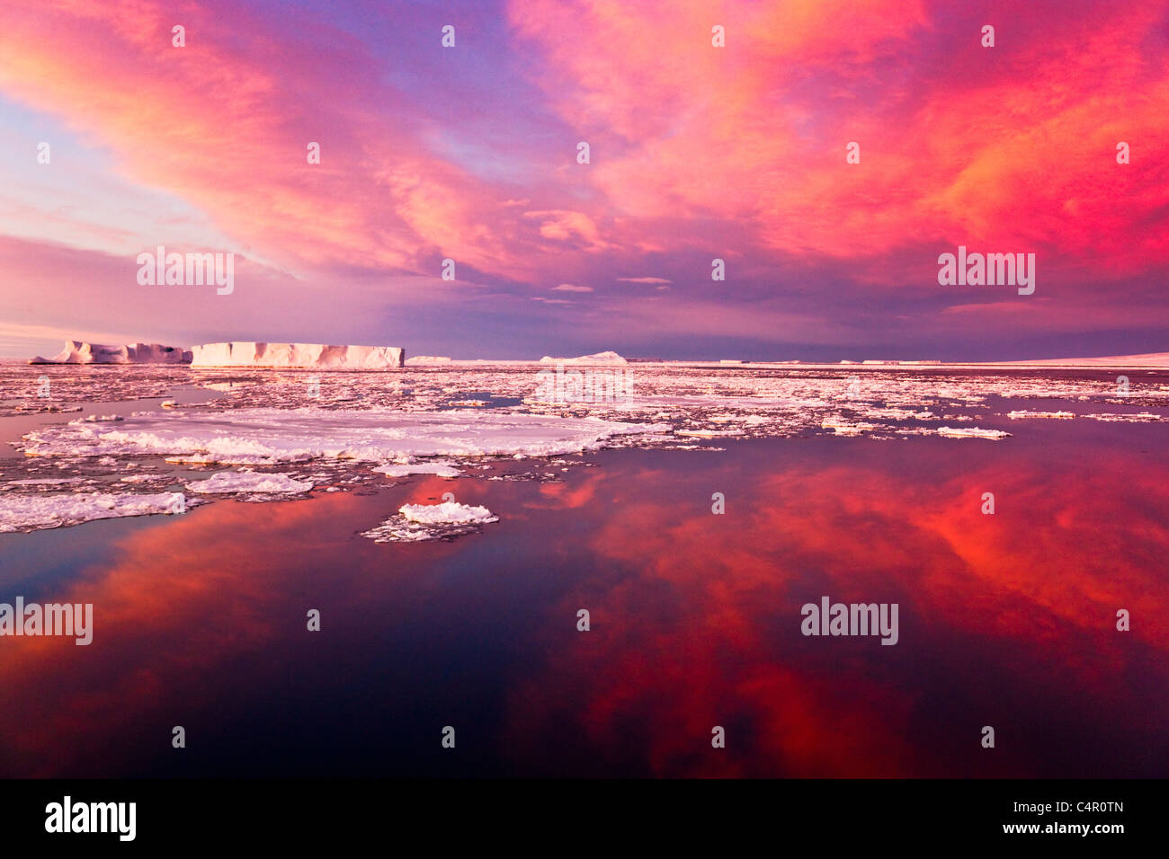 Riesiger Eisberg und Eisschollen im Meer bei Sonnenaufgang, Antarktis Stockfoto