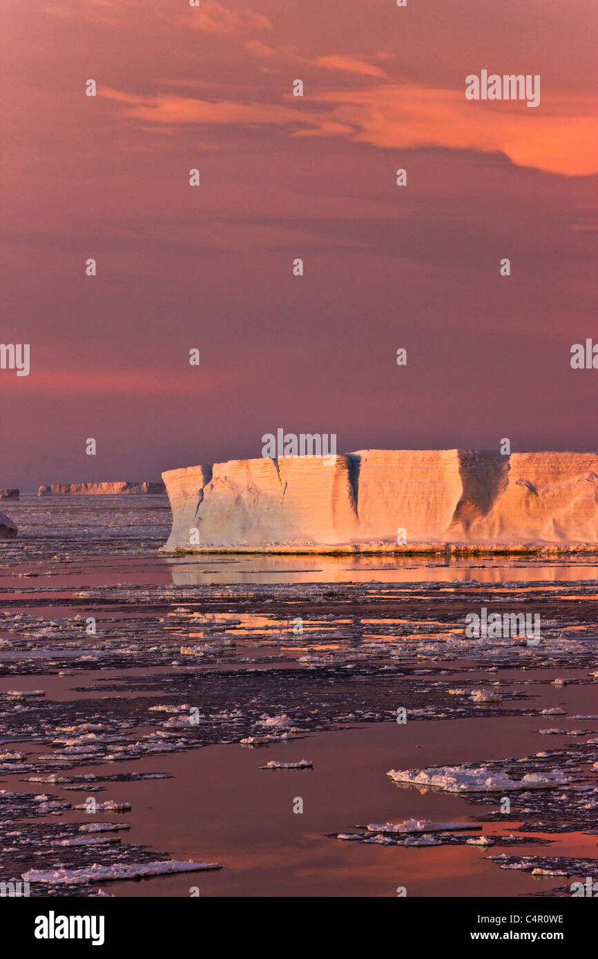 Riesiger Eisberg und Eisschollen im Meer bei Sonnenaufgang, Antarktis Stockfoto