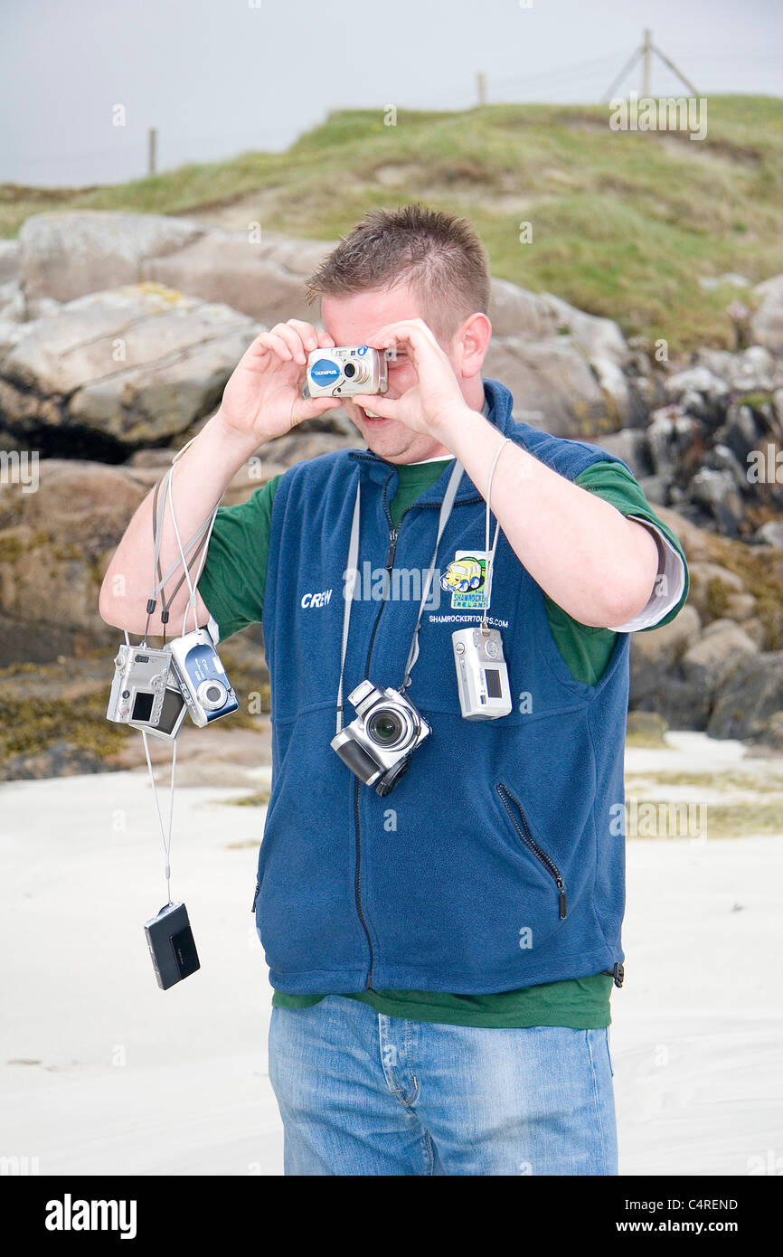 Ein Mann mit zahlreichen Kameras hängen um den Hals des Hundes Bay, Irland Stockfoto