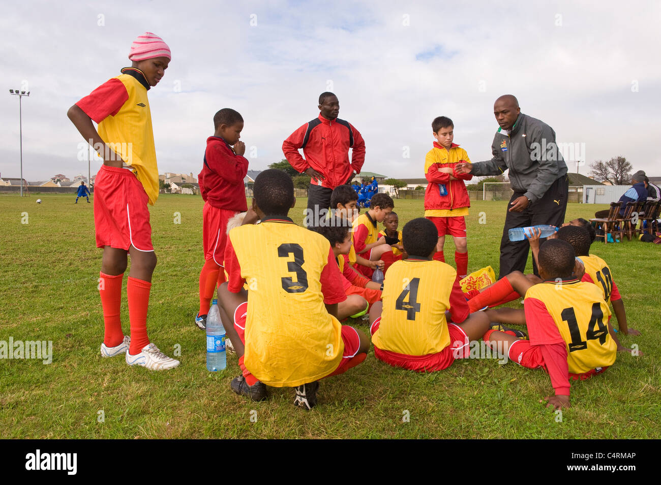 Fußball-Trainer unterrichten die Rygersdal unter 13-Team in der Halbzeitpause Cape Town South Africa Stockfoto