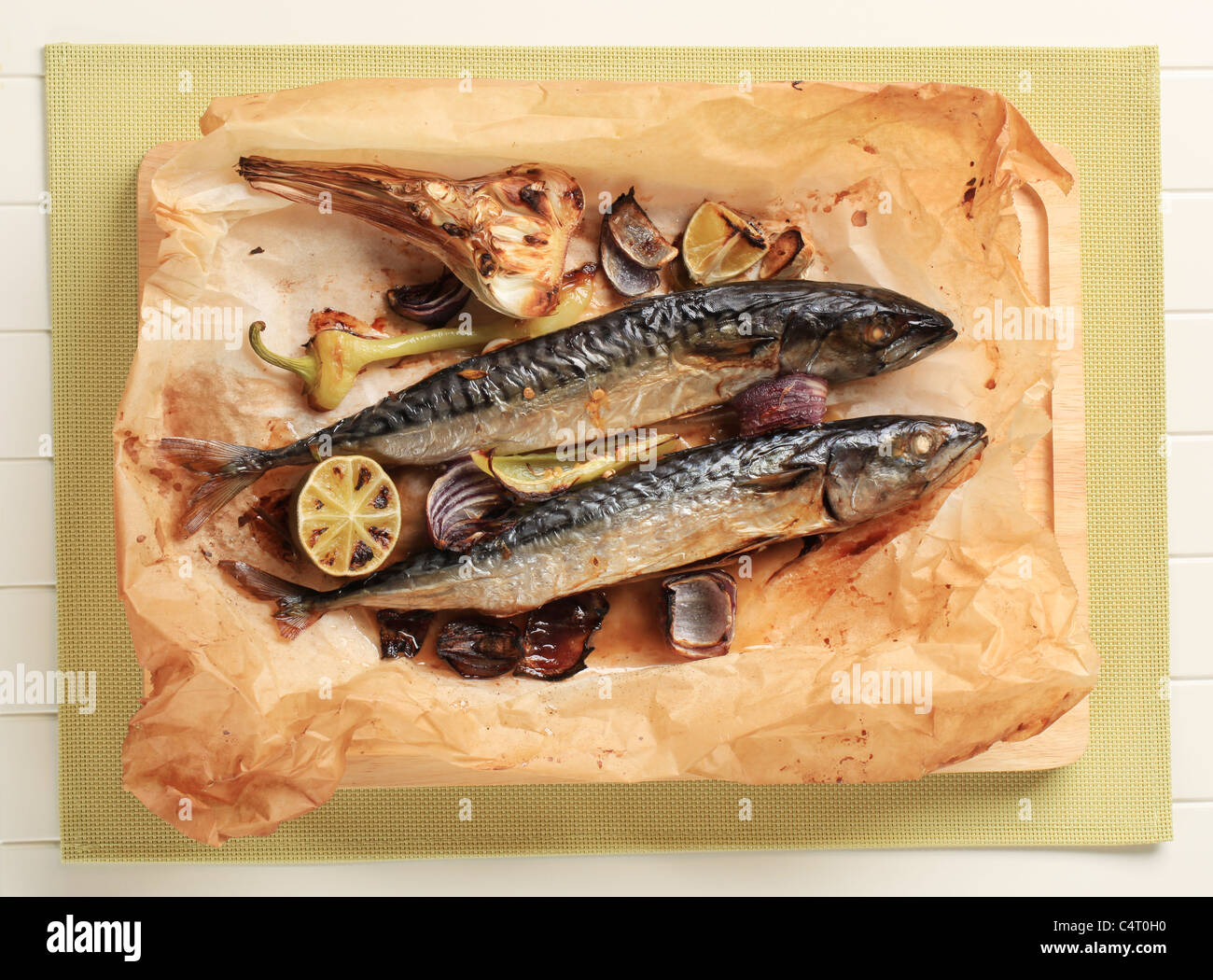 Gebackene Makrele und Gemüse auf Backpapier Stockfoto