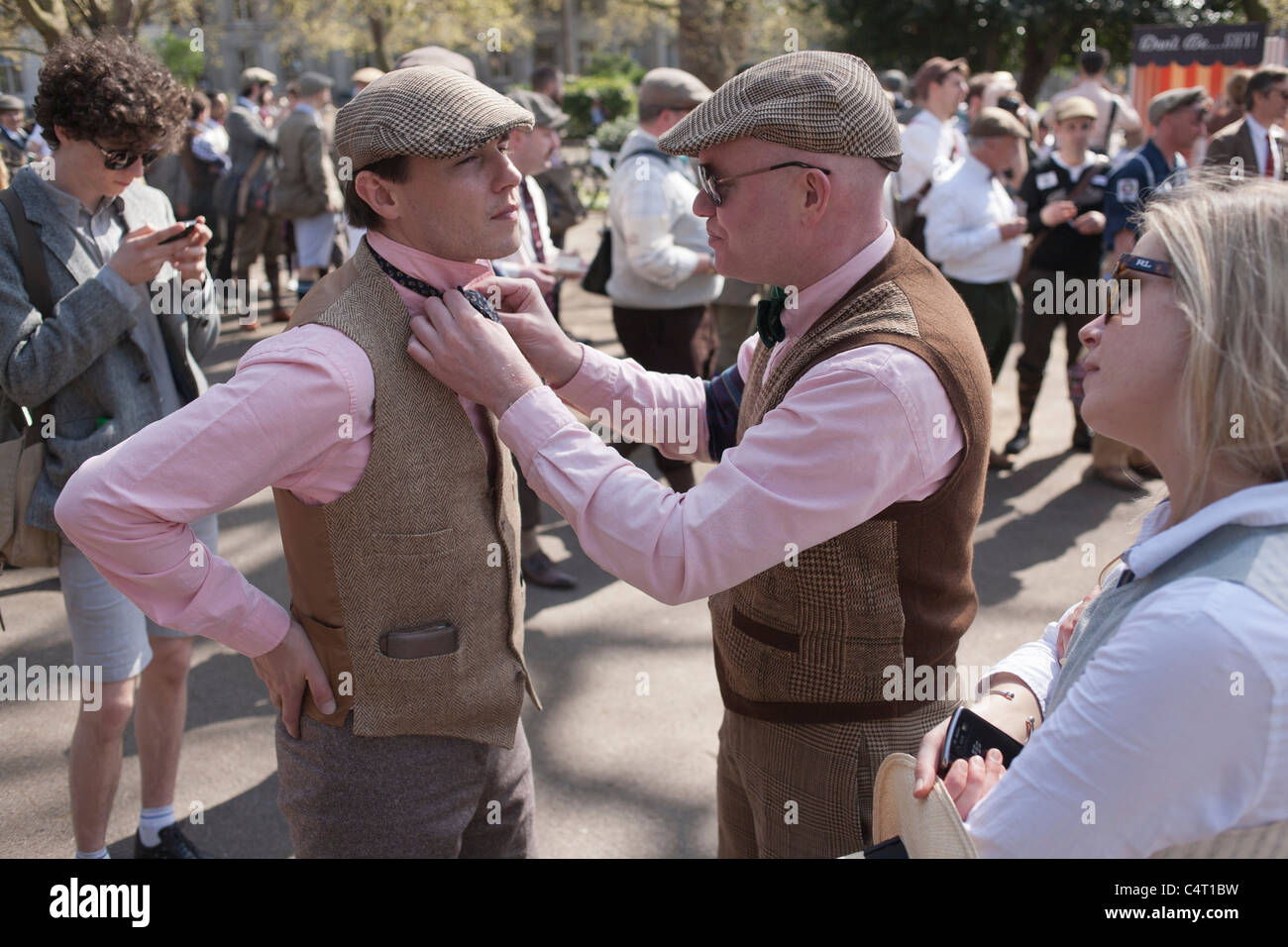 Ein Mann in einem Tweed Weste behebt die Fliege auf seinen passenden Freund beim London Tweed Run 2011 Stockfoto Ein Mann in einem Tweed Weste behebt die Fliege auf seinen passenden Freund beim London Tweed Run 2011 Stockfoto