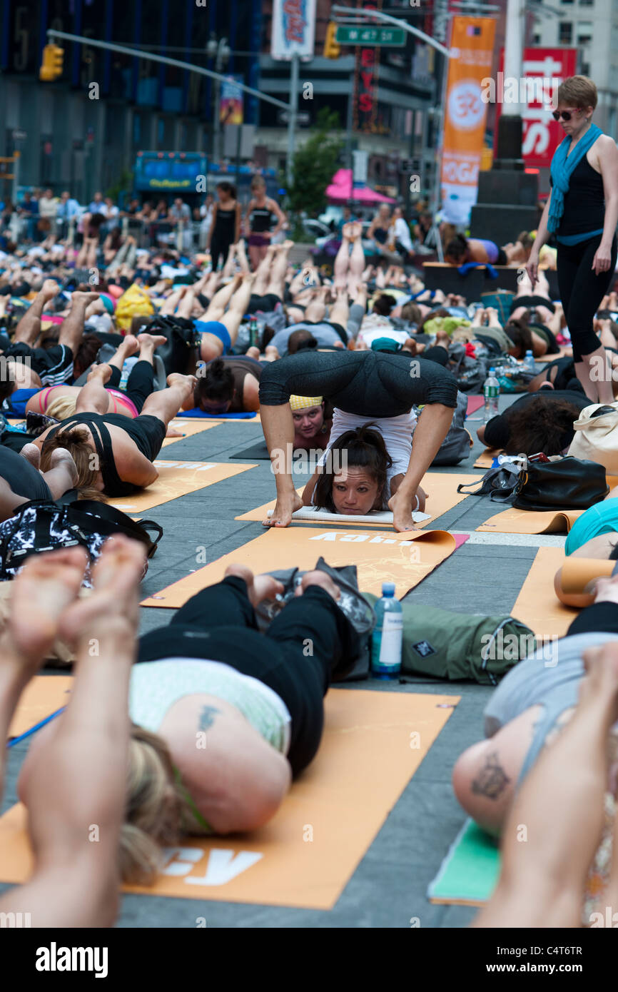 Tausende von Yoga-Praktizierende auf dem Times Square in New York teilnehmen, in einer Gruppe Yoga Beobachtung der Sommersonnenwende Stockfoto