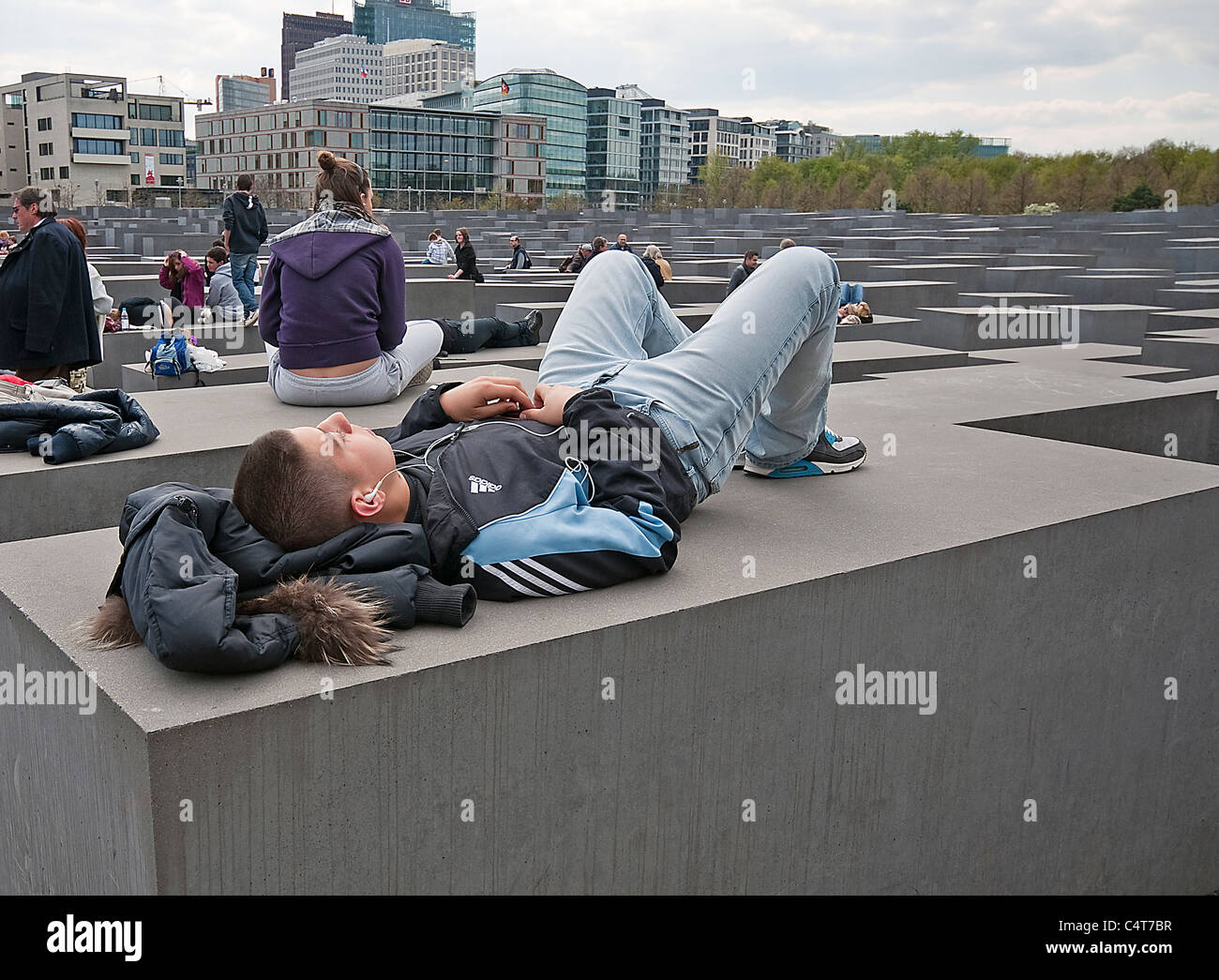 Mann schläft hören Ipod auf der Gedenkstätte für die Mudered Juden Europas, Berlin, Deutschland Stockfoto