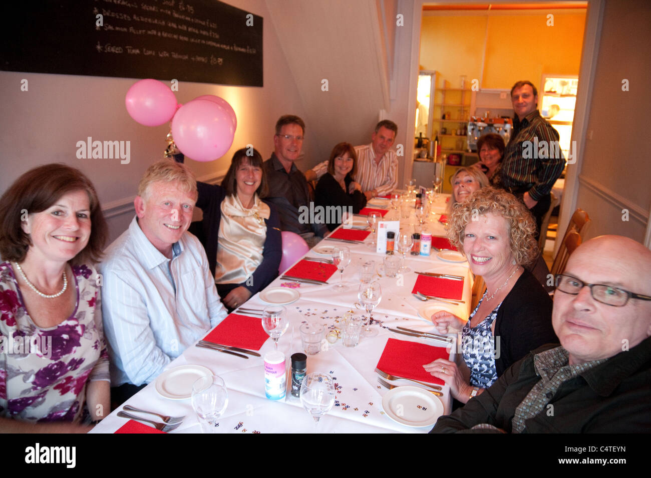 Eine Gruppe von 50 Somethings feiert 50. Geburtstag in einem Restaurant, UK Stockfoto