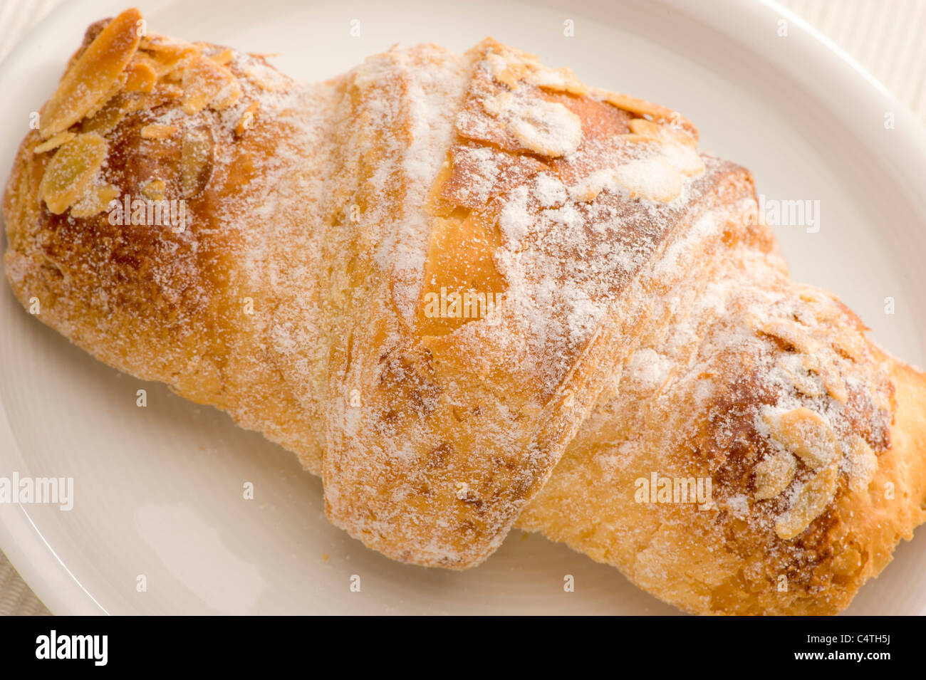 Nahaufnahme von Mandel Croissant auf einem weißen Teller Stockfoto