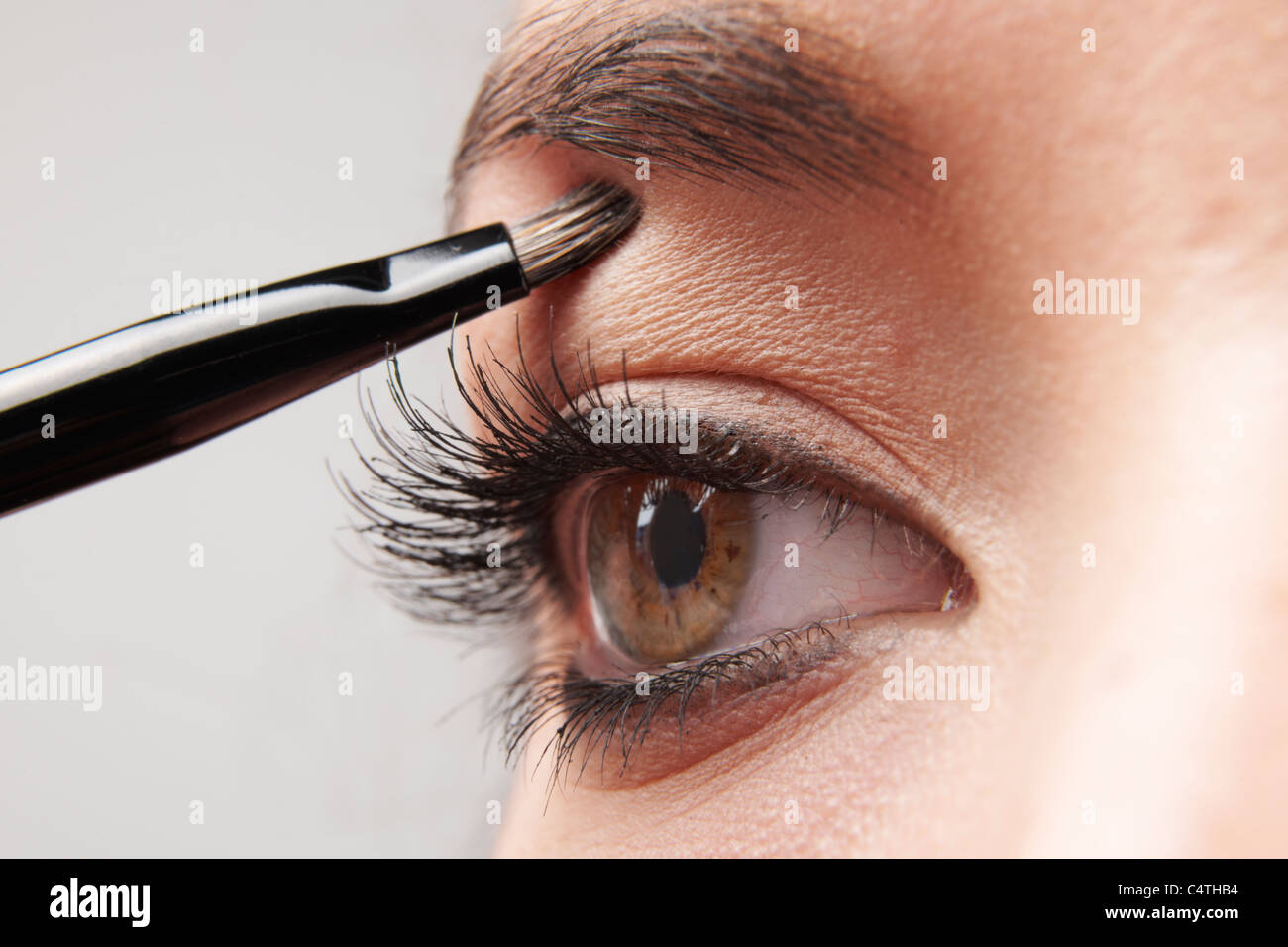 Frau Auge Schminken mit Pinsel auf weißem Hintergrund Stockfoto