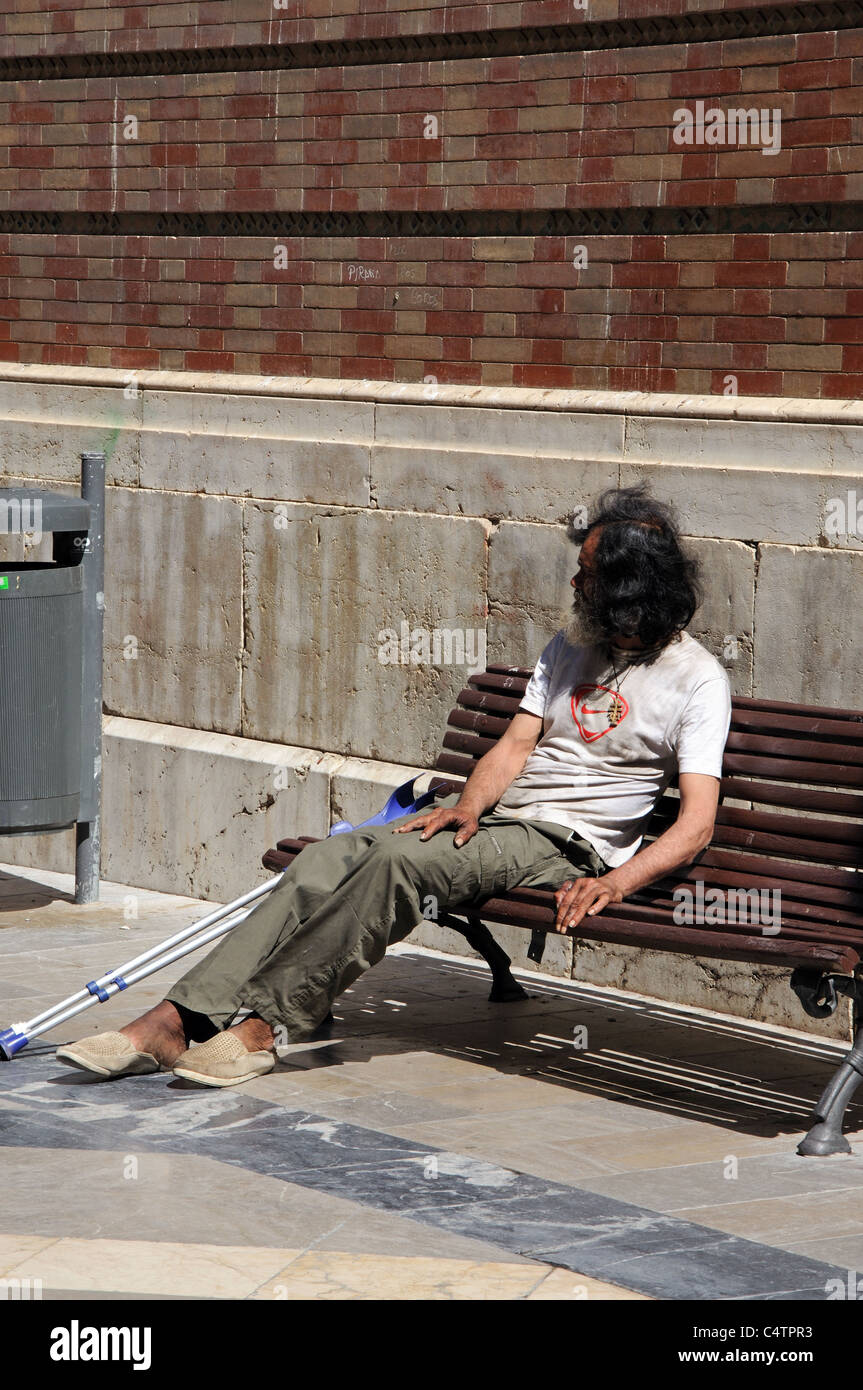 Menschen mit Behinderungen Landstreicher sitzen auf Bank von der Kathedrale, Malaga, Costa del Sol, Provinz Malaga, Andalusien, Spanien, Westeuropa. Stockfoto