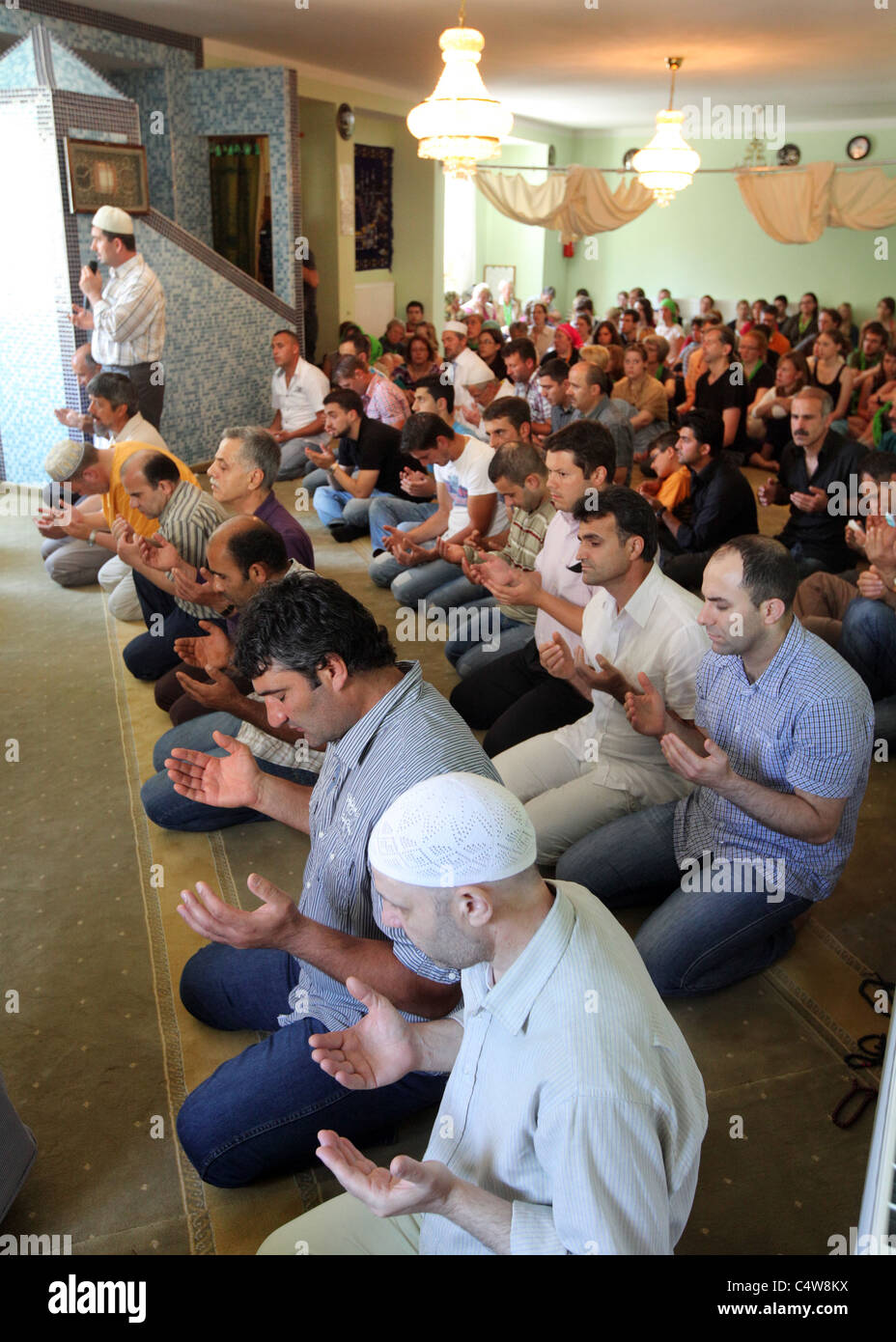 türkische Muslime (vorne) von Deutsche Christen (zurück) beobachtet, während ein Freitagsgebet in einer Moschee in Dresden, Deutschland. Stockfoto