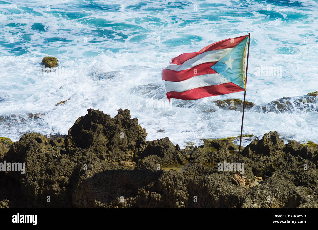 Old San Juan, Puerto Rico Puerto-Ricanischen Flagge auf Felsen mit Meer im Hintergrund Stockfoto
