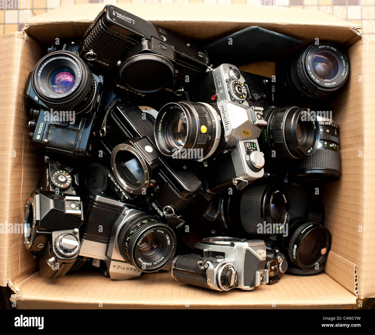 ein Karton von sortierten verwendet alte gebrauchte 35mm alte Film SLR Kameragehäuse und Objektive, UK Stockfoto