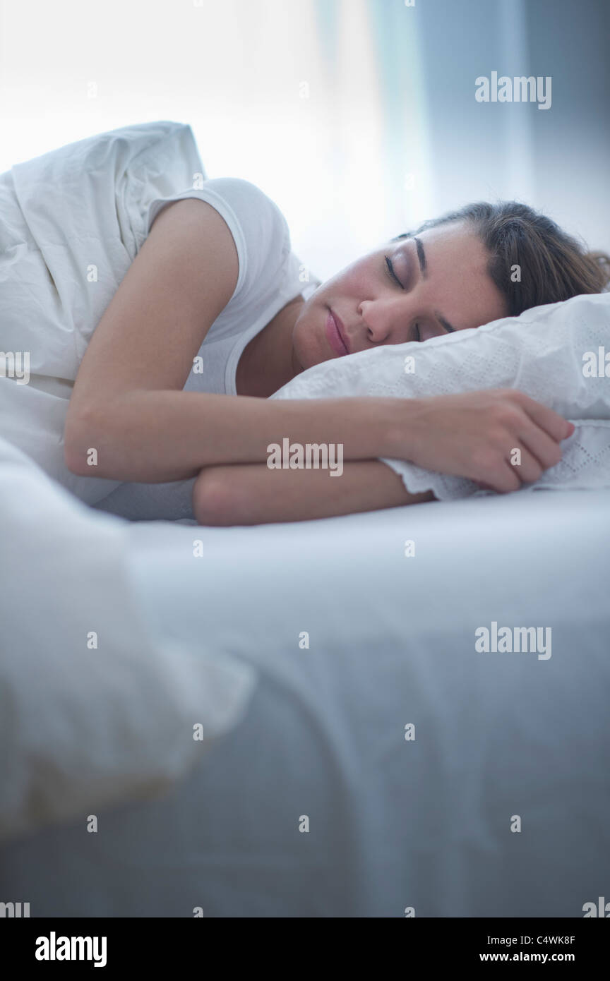 USA, New Jersey, Jersey City, glückliche junge Frau im Bett schlafen Stockfoto