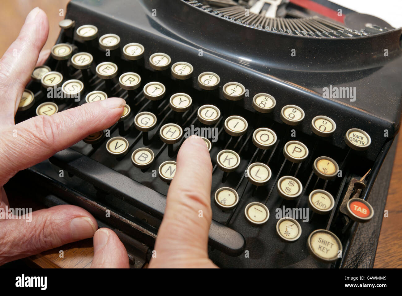 Ein pensionierter älterer Senior Mann auf einer Schreibmaschine zu tippen. Stockfoto