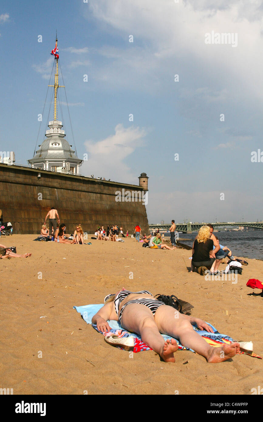 Menschen, die Sonnen am Strand in der Nähe von Peter und Paul Fortress in Sankt Petersburg, Russland Stockfoto