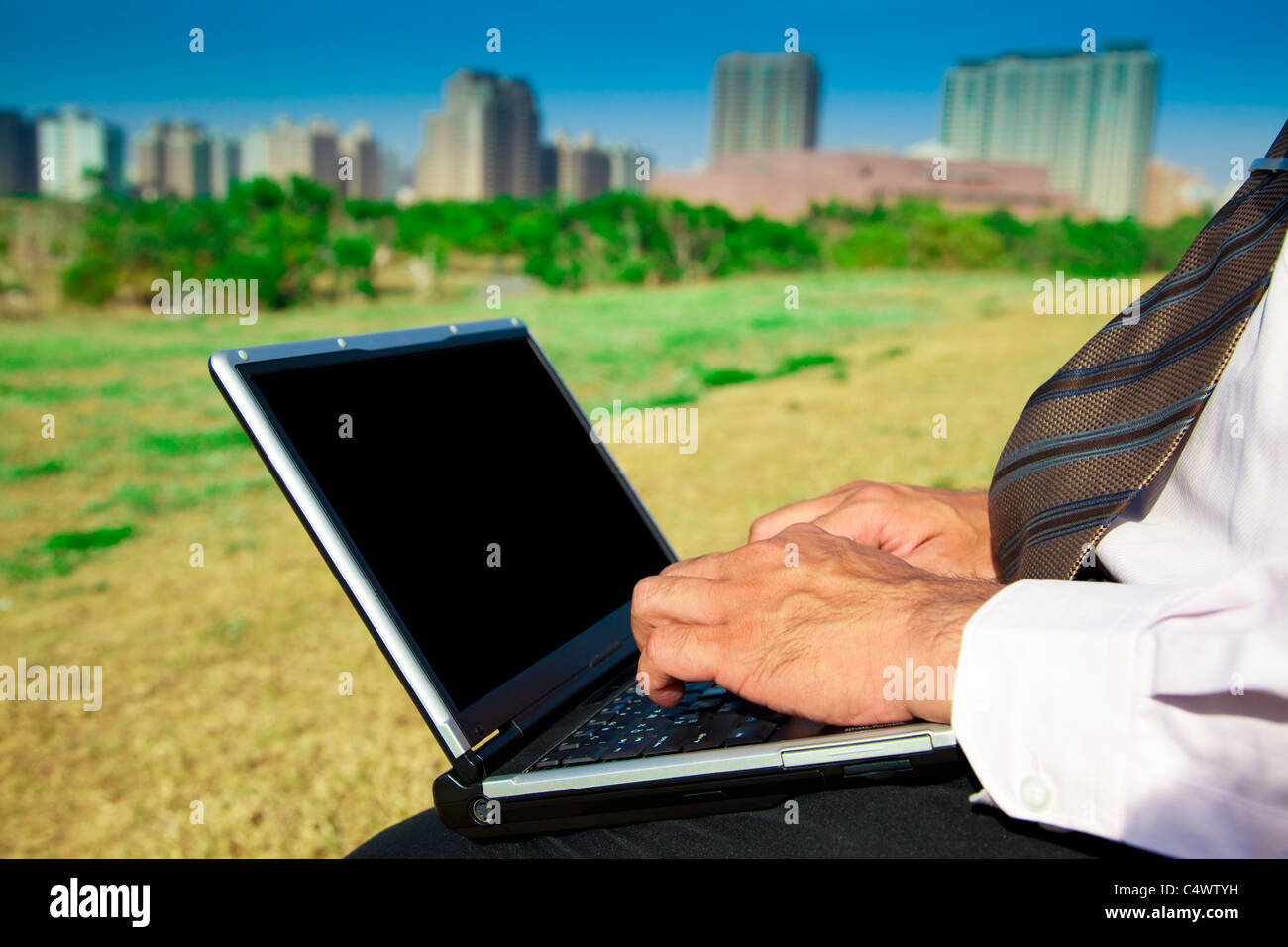 Geschäftsmann, arbeiten auf einem Laptop im Freien sitzen auf einer Parkbank Stockfoto