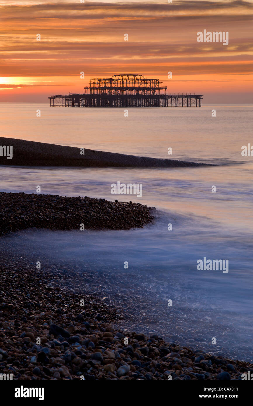 Sonnenaufgang hinter den Überresten von Brightons West Pier, Sussex, UK Stockfoto