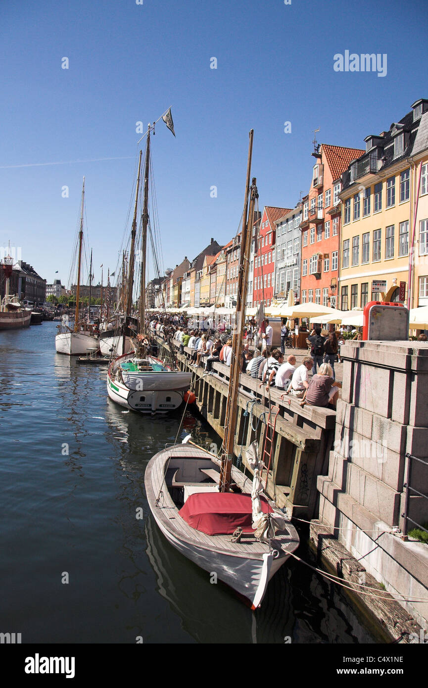 Touristen und Boote auf der beliebten Uferpromenade, Nyhavn Hafen, Kopenhagen, Dänemark Stockfoto
