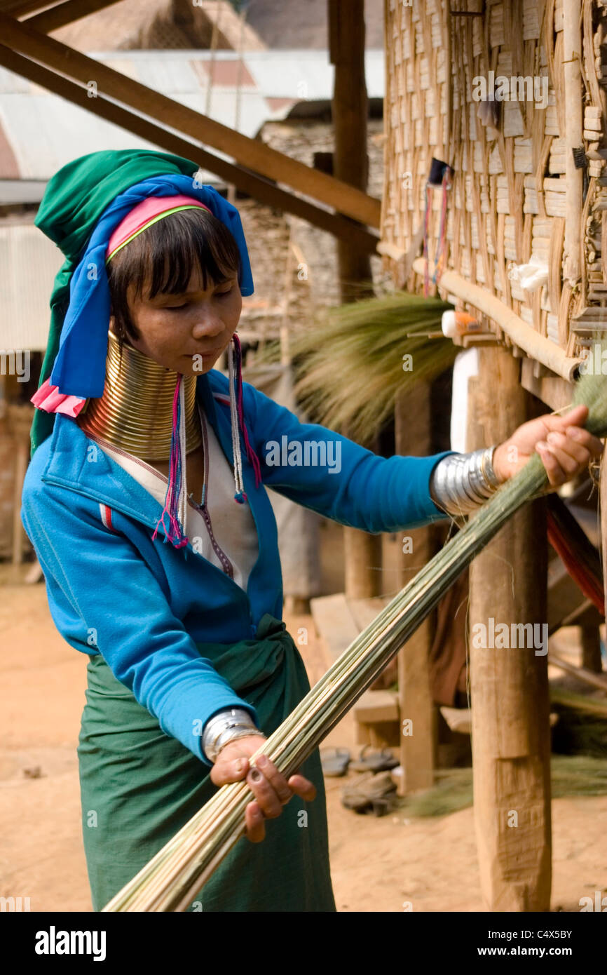 Frau Karen Paduang aus Burma gold Ringe um den Hals tragen macht einen Besen bei ihr zu Hause in einem Flüchtlingslager in Thailand. Stockfoto