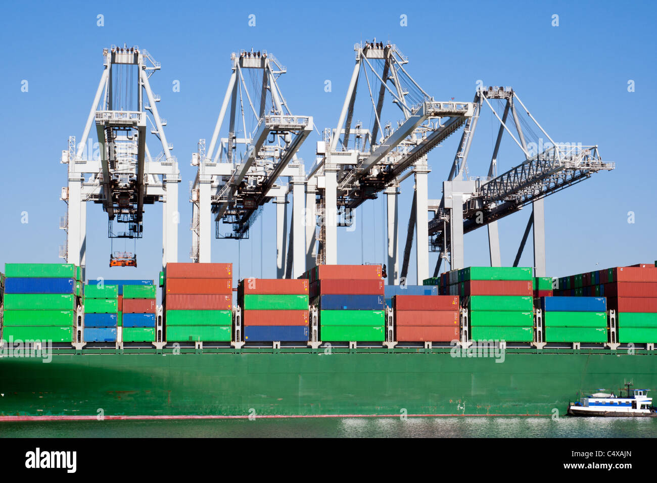 Große Hafenkräne beladen ein Containerschiff Stockfoto