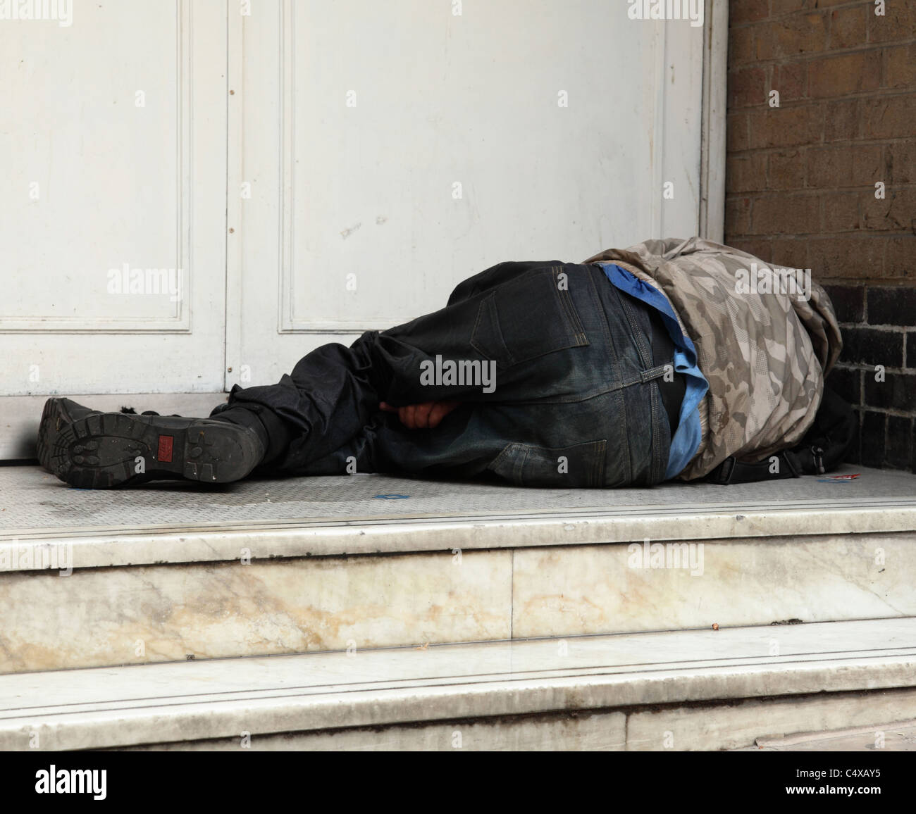 Ein Obdachloser schlafen rau in einem Hauseingang in einer Stadt, U.K. Stockfoto