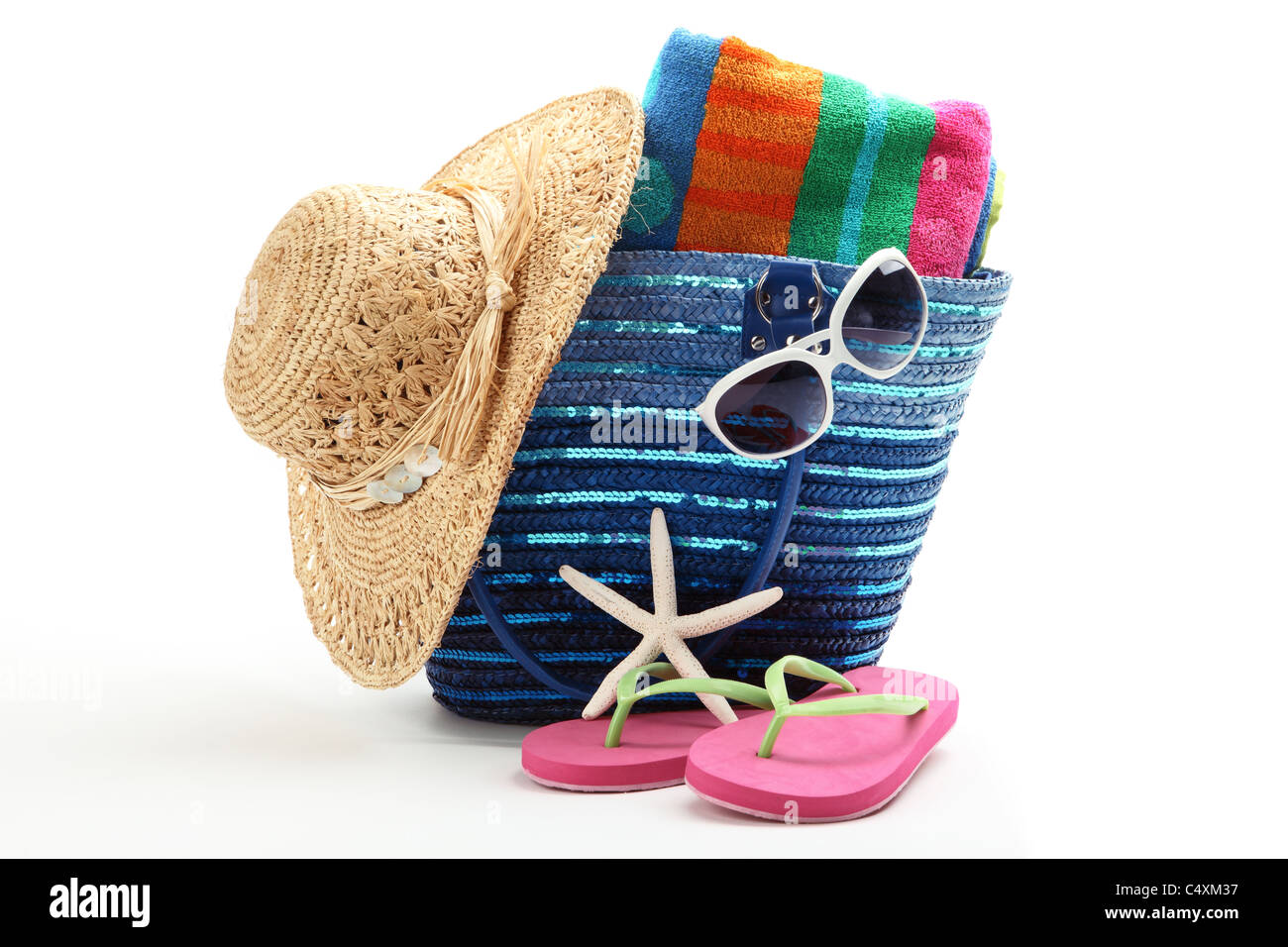 Strandtasche mit Strohhut, Handtuch, Flip Flops und Sonnenbrillen. Isoliert auf weißem Hintergrund. Stockfoto