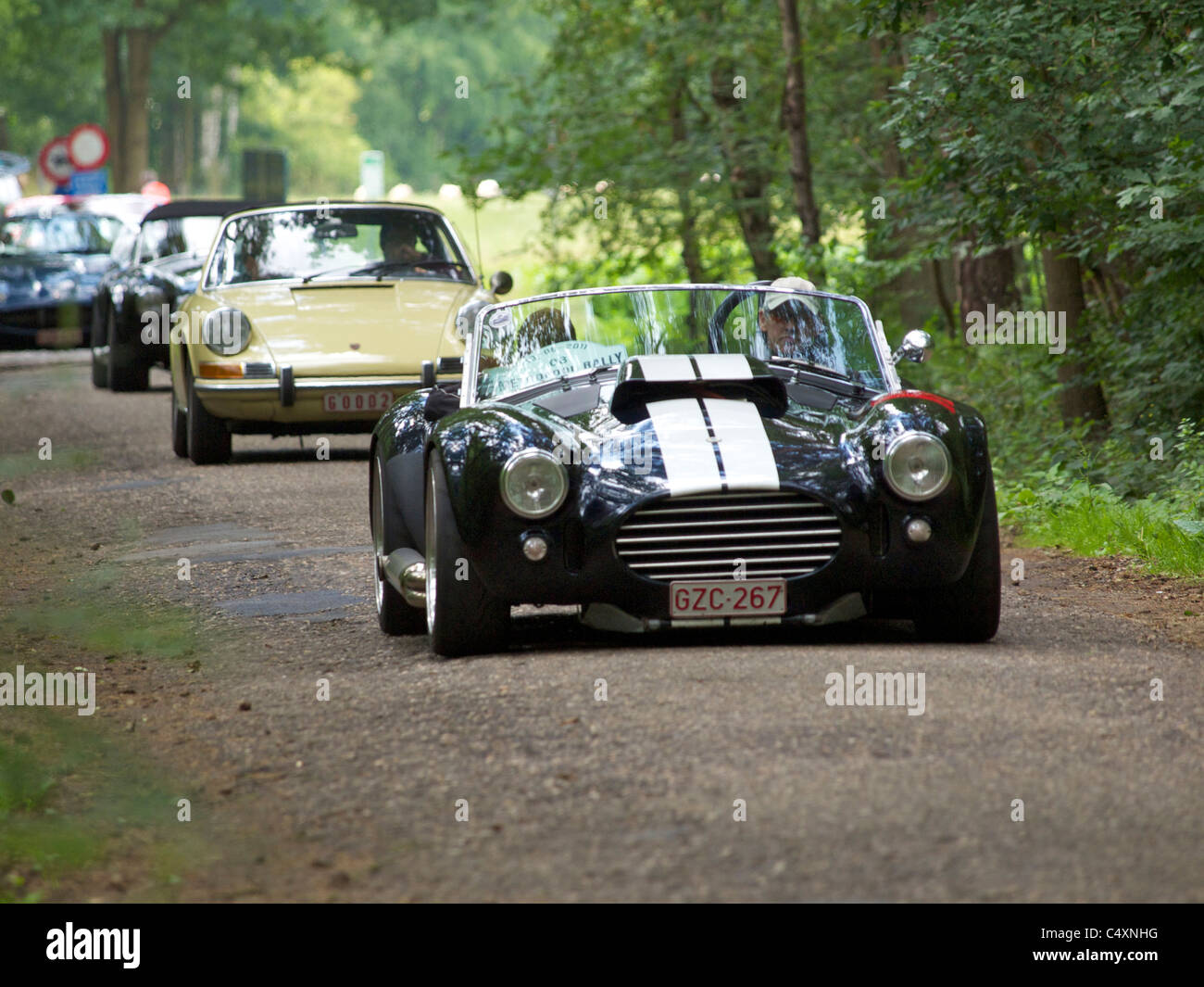 Oldtimer-Rallye in der belgischen Landschaft, AC Cobra 427 vor gefolgt von Porsche 911. Stockfoto