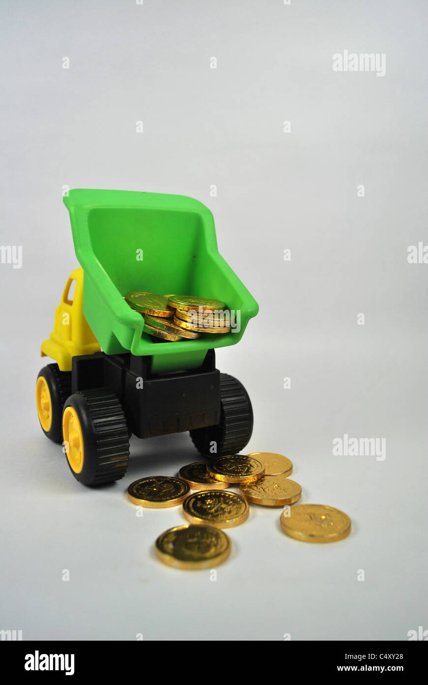 Spielzeug verspielt LKW LKW mobile Auto Reichtum Geld Goldmünze Silo  ausgeschnitten ausgeschnittenen weißen Hintergrund isoliert gelb grün  schwarz Stockfotografie - Alamy
