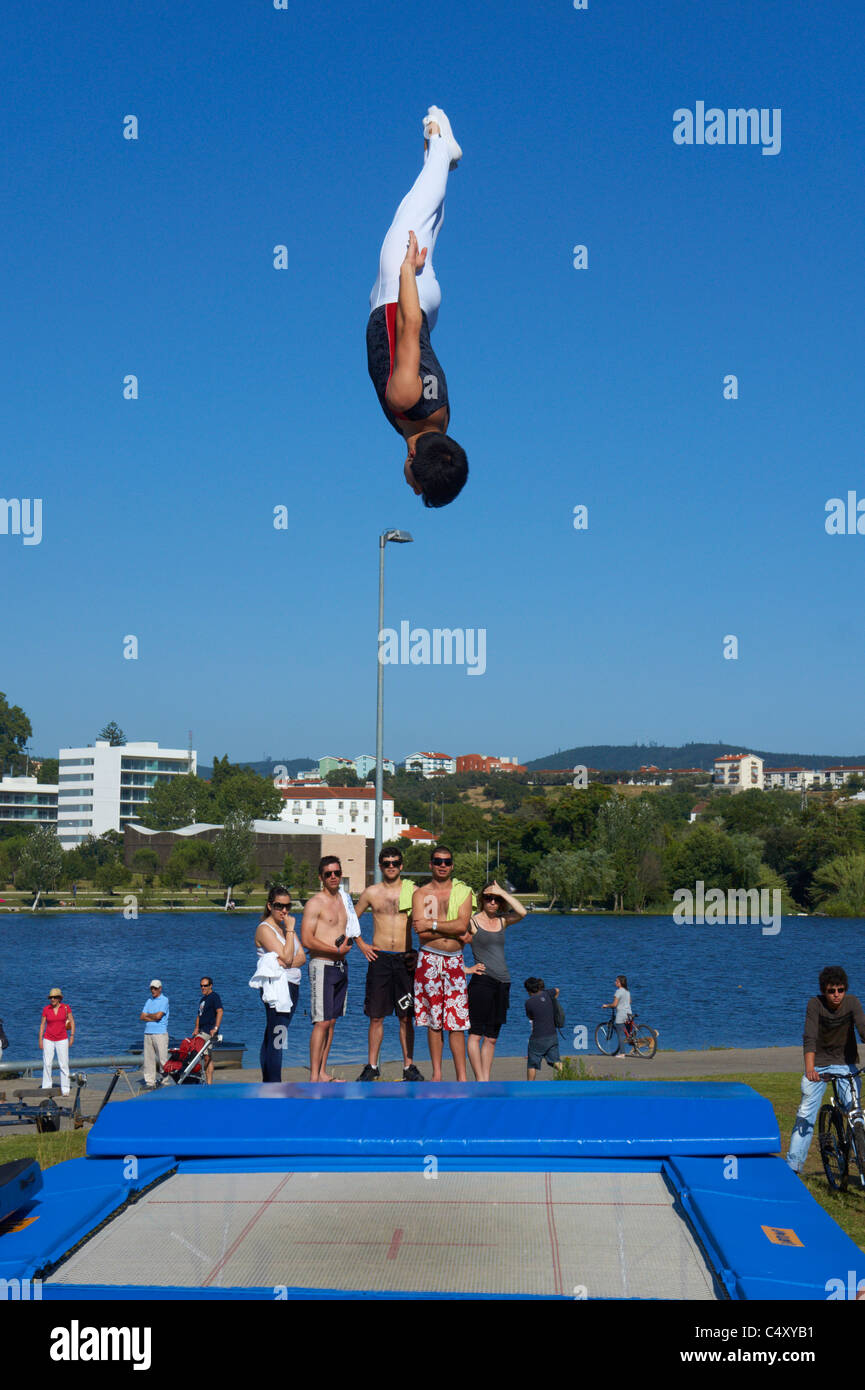 Männliche Turnerin abspringen Trampolin in die Luft vor blauem Himmel Stockfoto