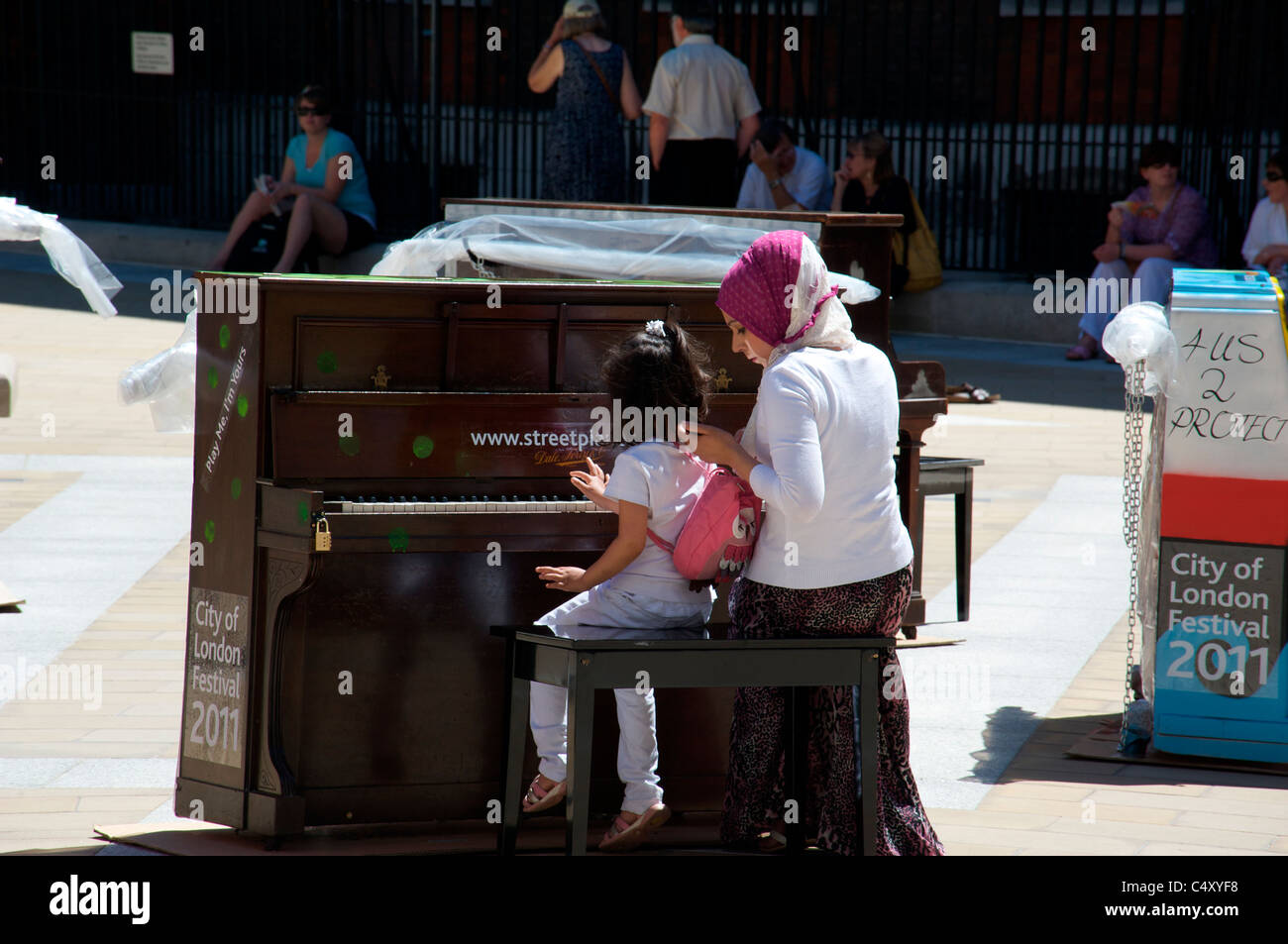 Mutter und Tochter ausprobieren die Straße Klaviere in der City of London Festival 2011 Stockfoto