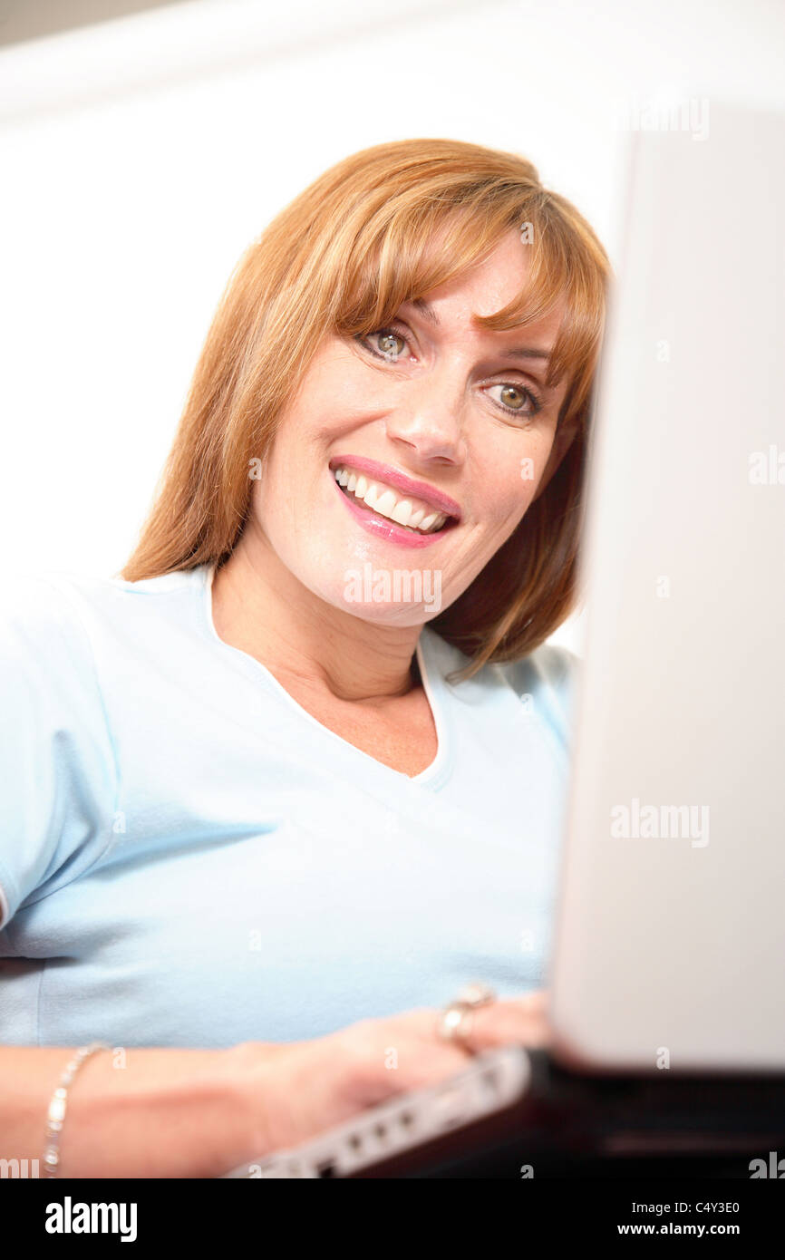 Frau mit einem Laptop-Computer, lächelnd. Stockfoto