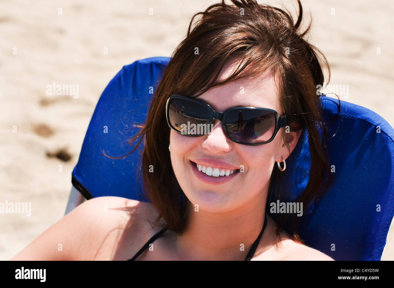 Eine schöne Brünette sitzt in einem Strandkorb auf dem Sand in Sayulita, Nayarit, Mexiko. Stockfoto