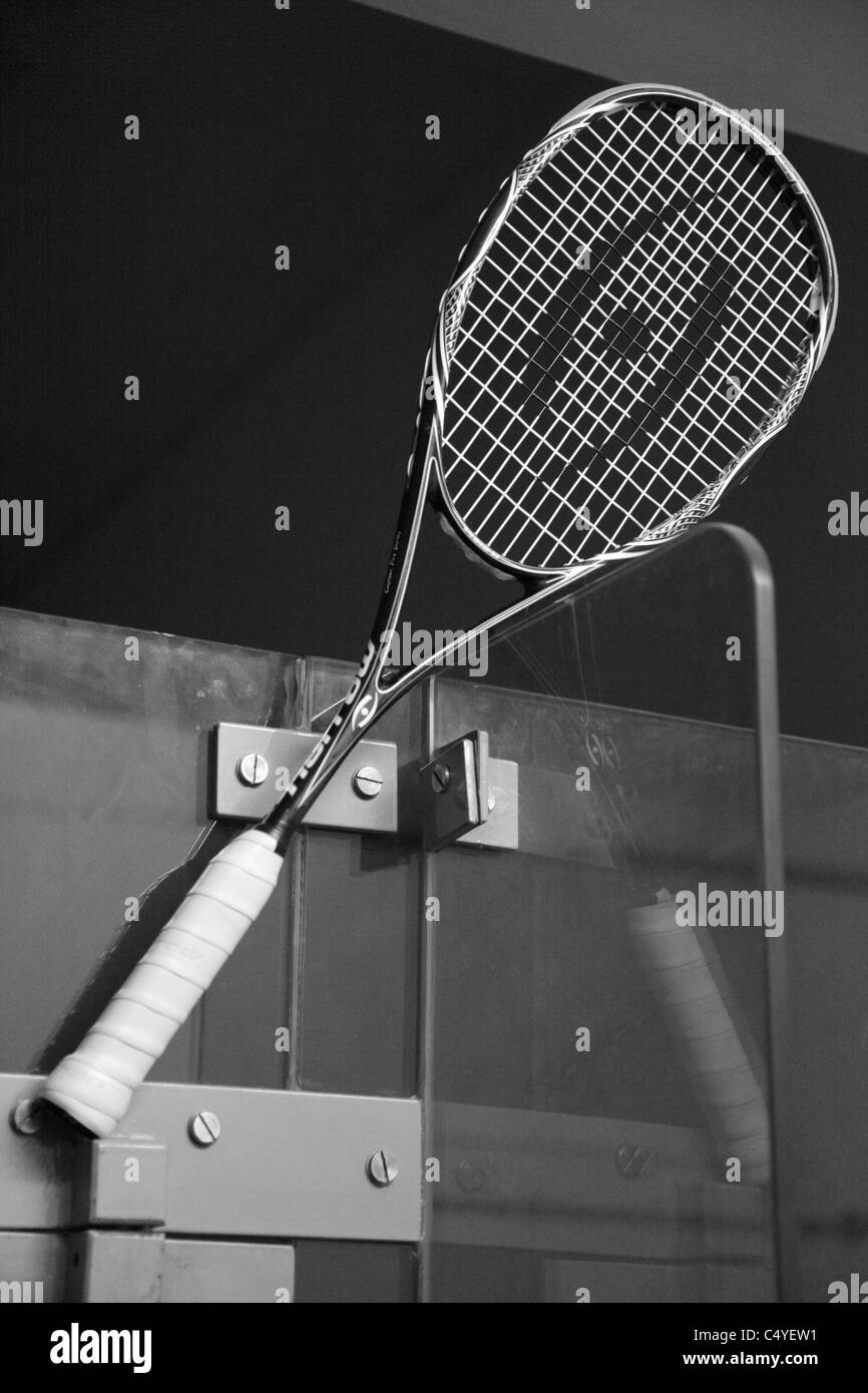 Ein Squash-Schläger thront auf einem die Tür eines Glases unterstützt squash Court Stockfoto