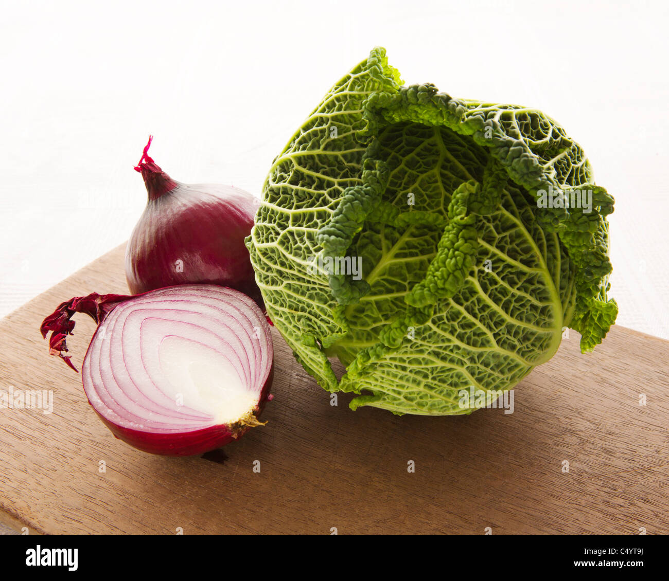 Rote Zwiebel mit Kohl auf Holzbrett schneiden Stockfoto