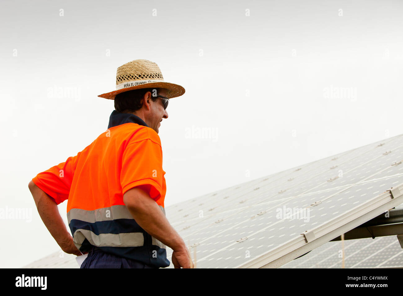 Ein Mann Überprüfung Foto voltaic Paneelen auf einer Photovoltaik-Anlage in der Nähe von Lucainena de Las Torres, Andalusien, Spanien. Stockfoto