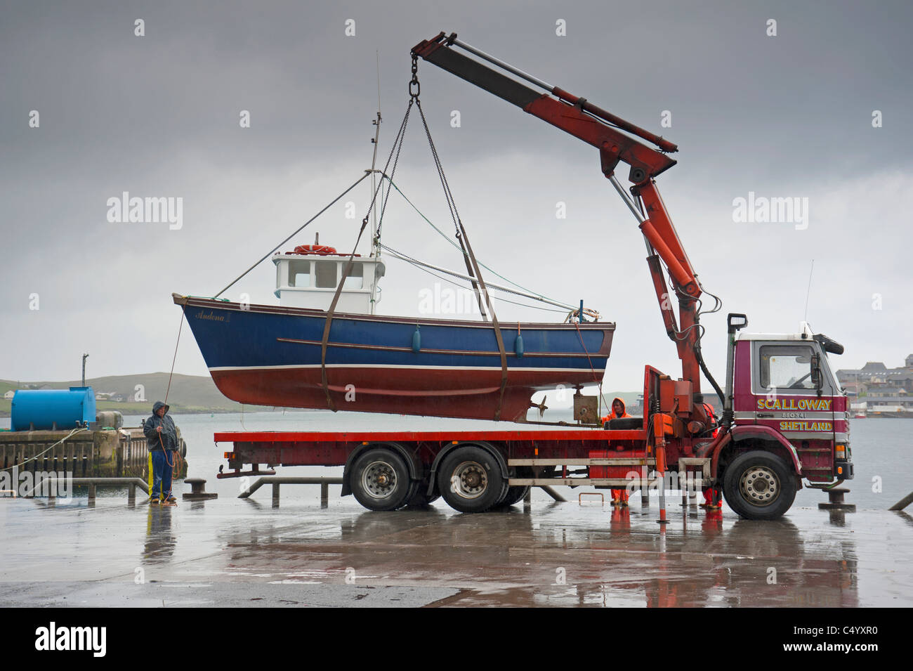 Angelboot/Fischerboot aus dem Meer vor Antifouling Arbeit entfernt beginnt auf dem Rumpf, Scalloway Pier Shetland. SCO 7371 Stockfoto